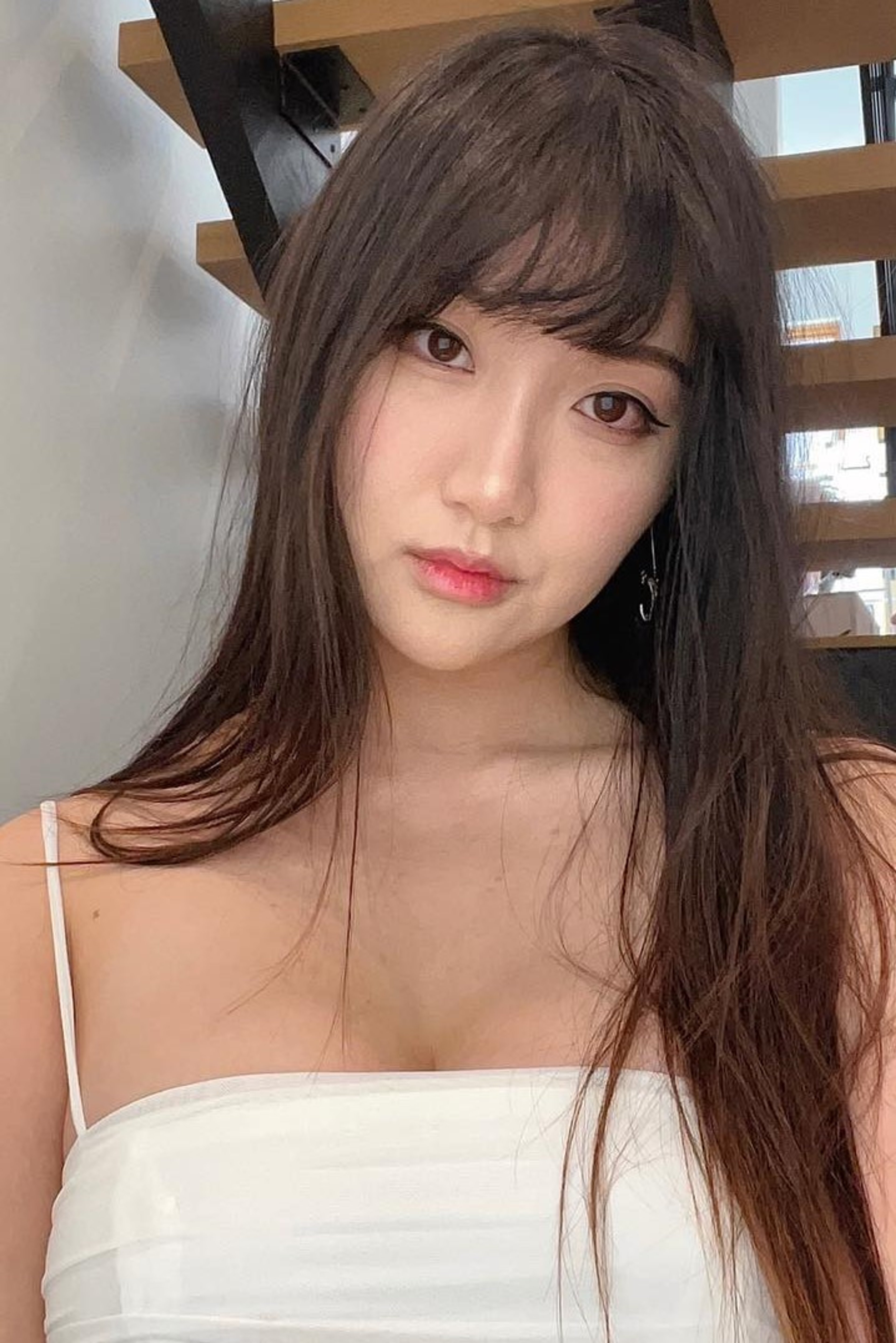 A young woman with long brown hair and a friendly expression