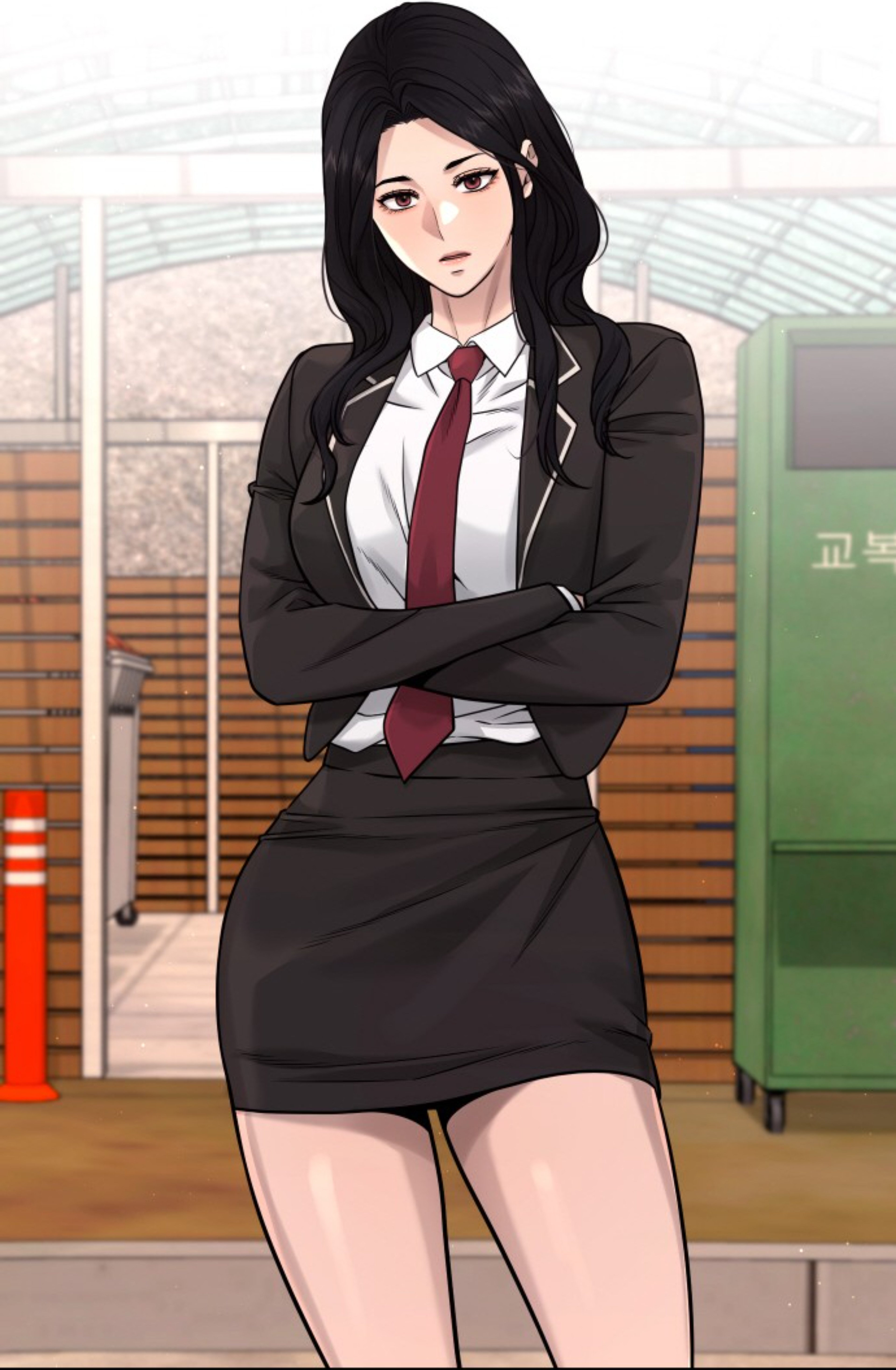 A young woman in a black suit and red tie with a serious expression