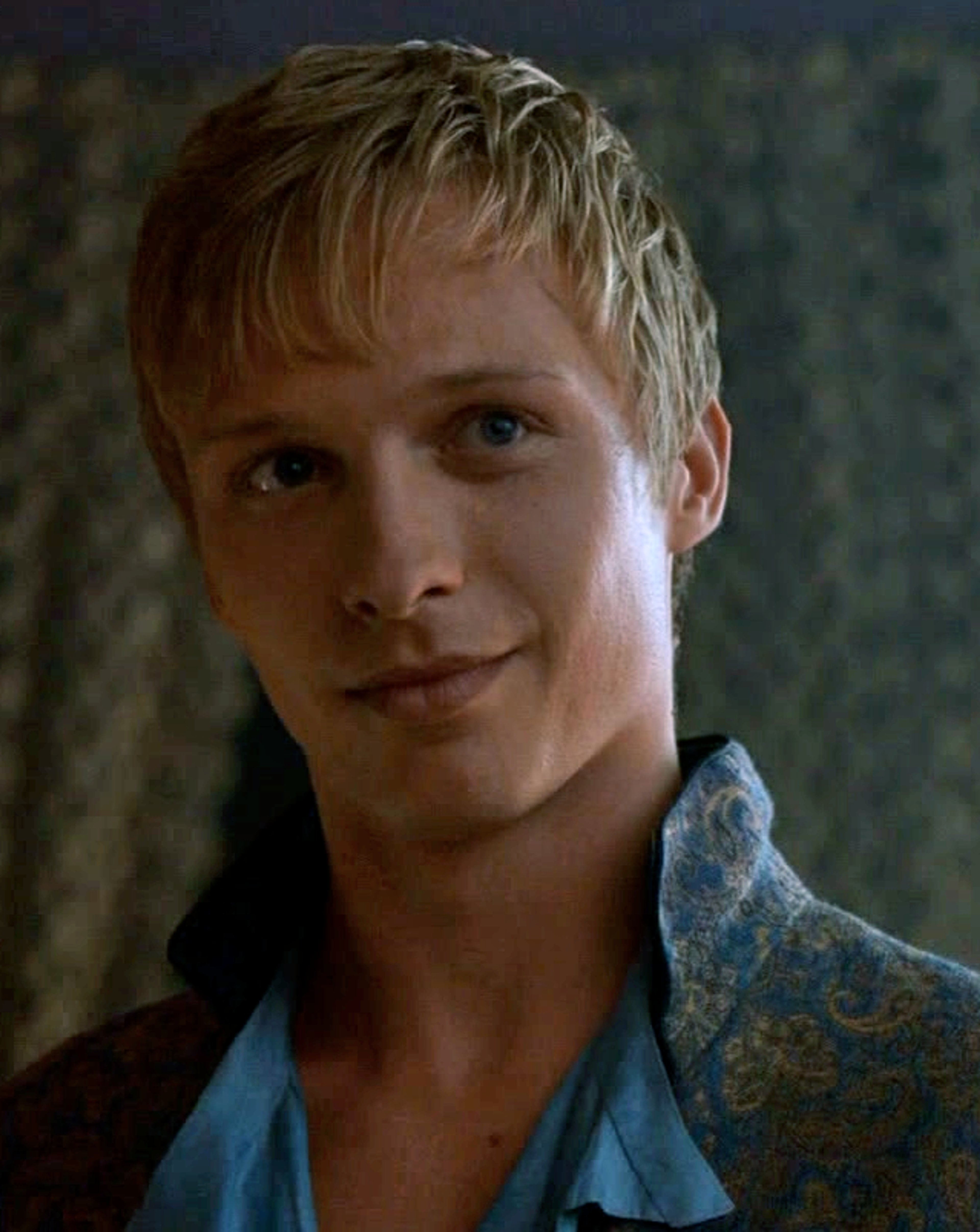 A young, attractive man with short blonde hair and a confident expression