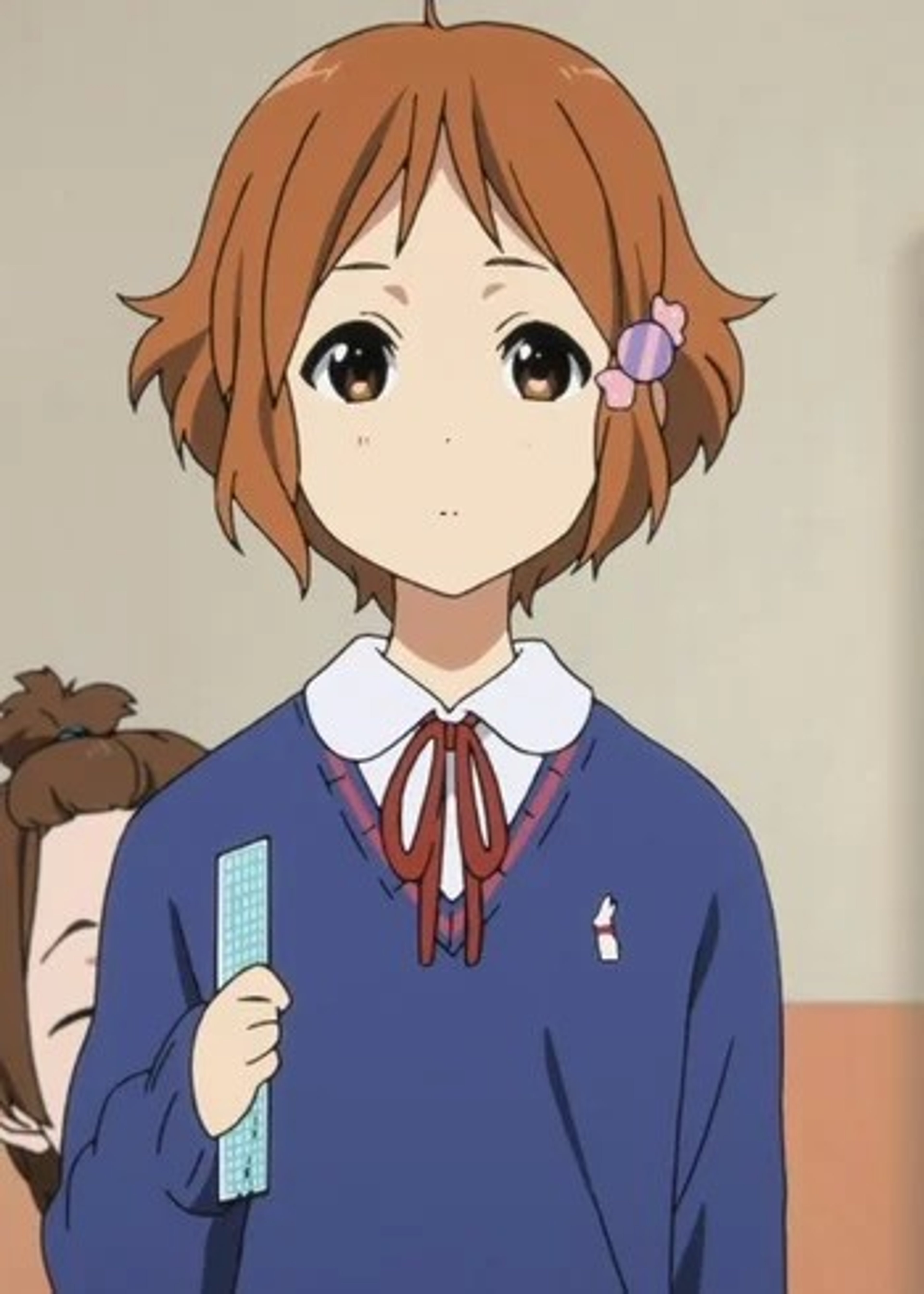 An anime-style character with short, reddish-brown hair wearing a blue school uniform with a red bow tie.