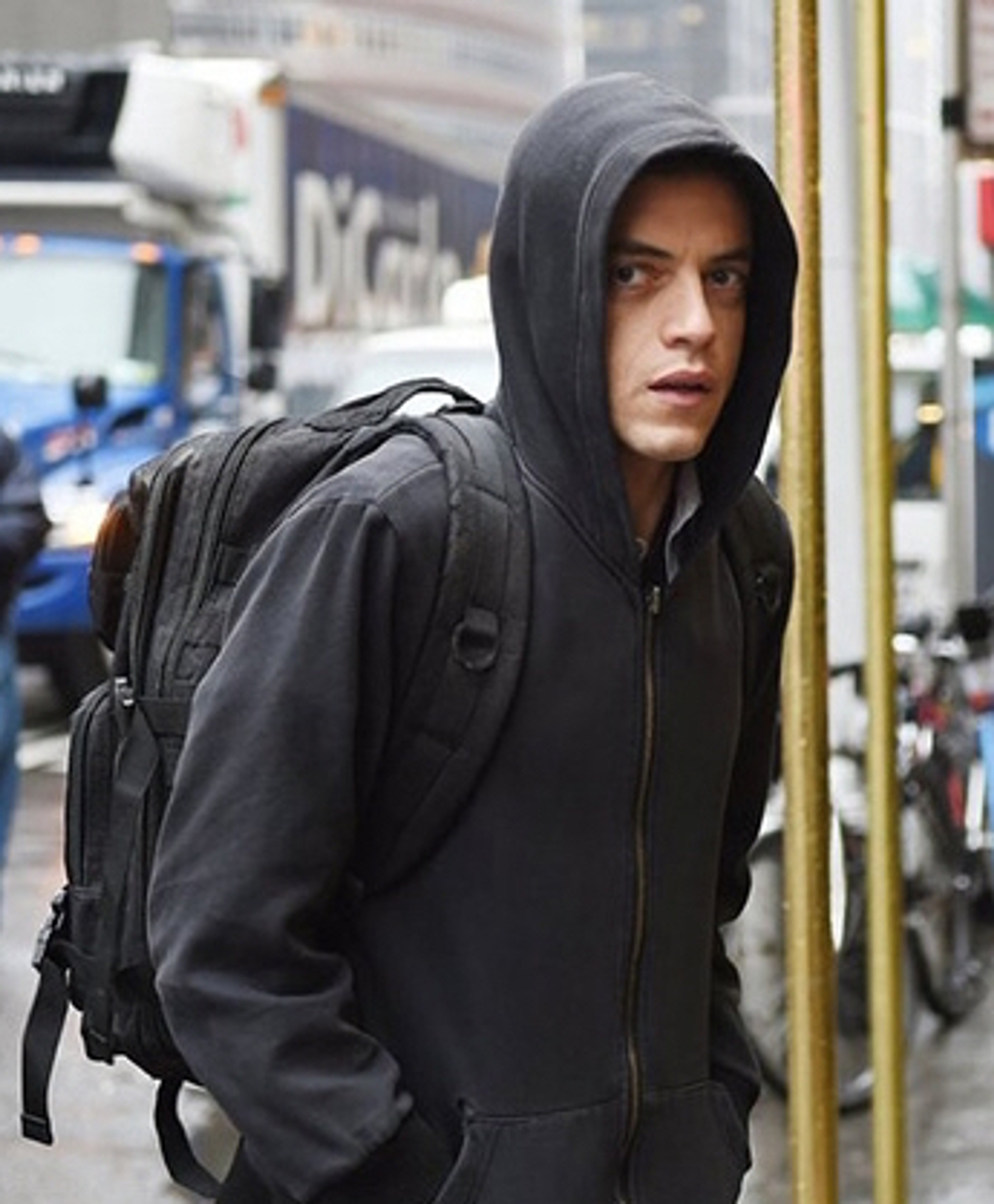 A young man with dark hair wearing a black hooded jacket