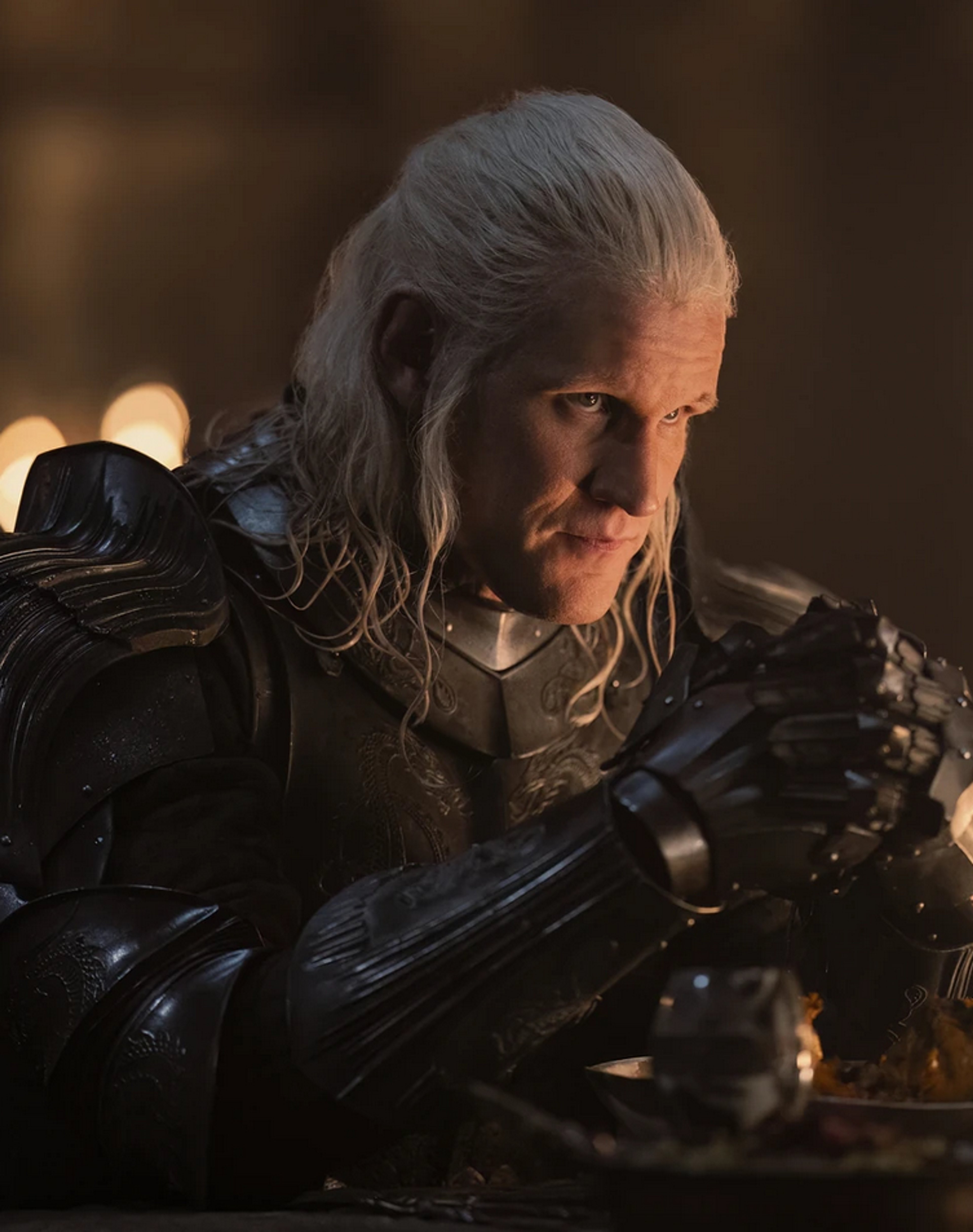 A man with long, silver-white hair and a beard, wearing dark armor and wielding a sword.
