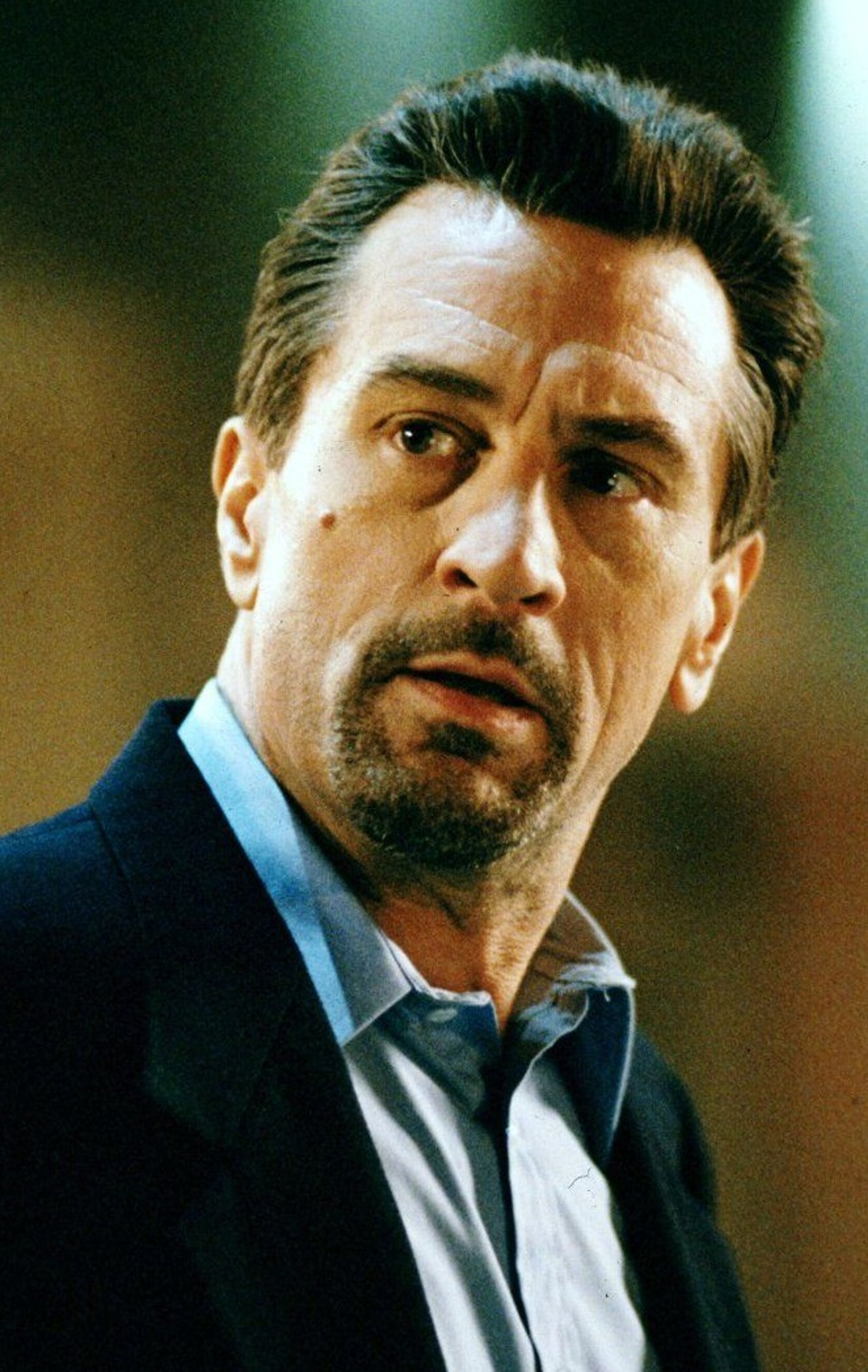 A middle-aged man in a suit with a serious expression