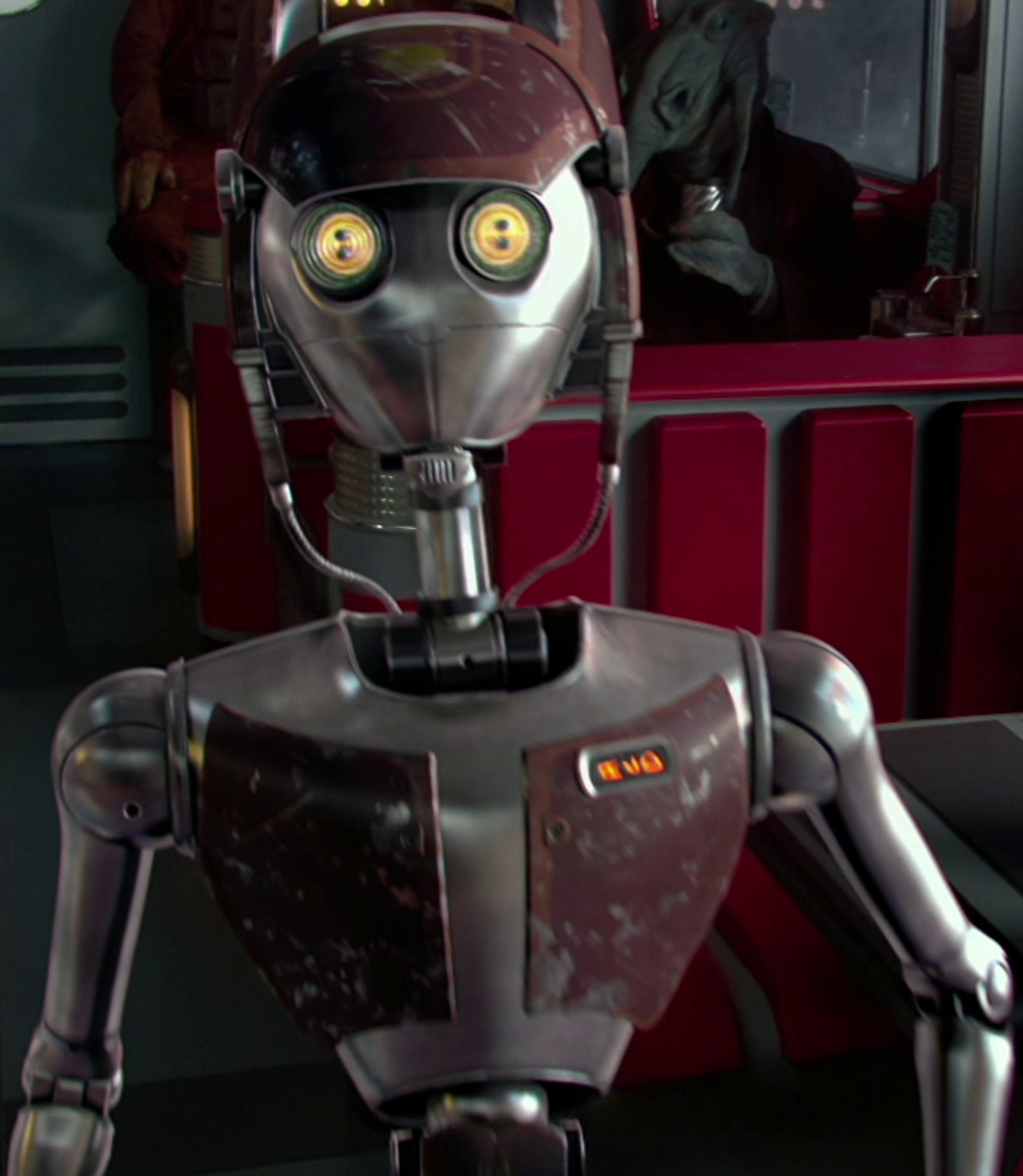 A metallic service droid with multiple arms and yellow sensor lights, designed for restaurant service.