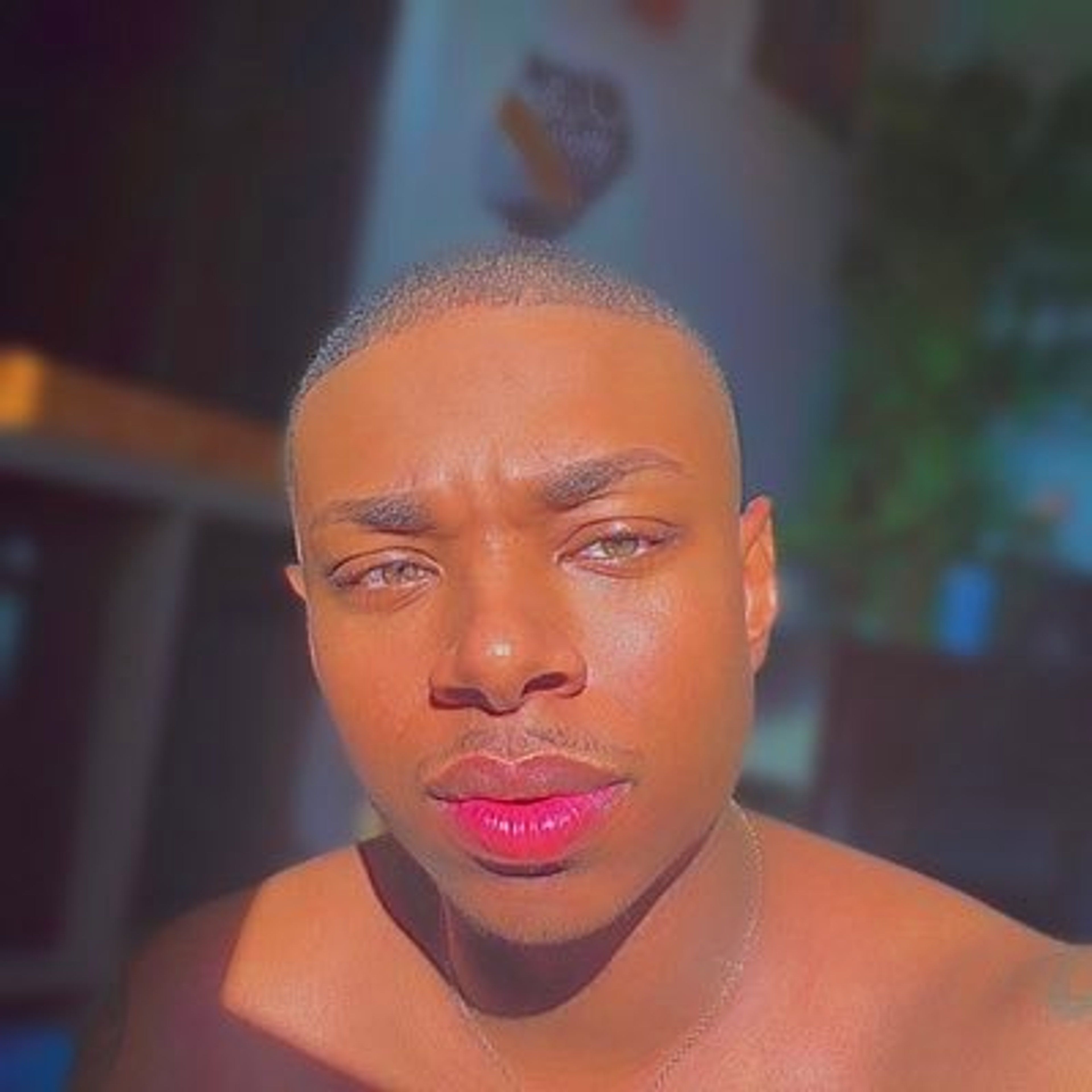 Close-up portrait of a Black man with a shaved head and intense facial expression