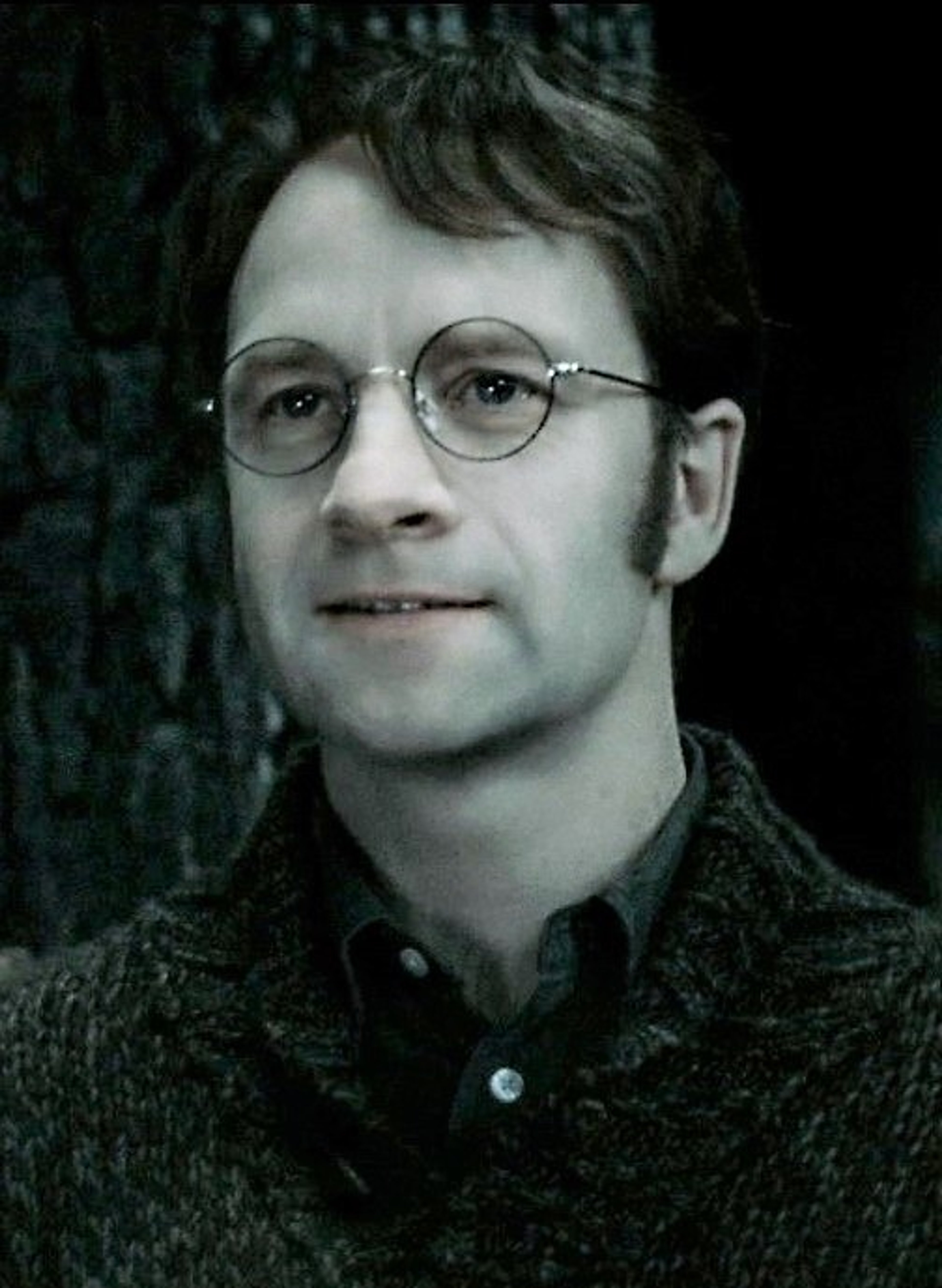 A young wizard character with untidy black hair and round glasses, smiling at the camera.
