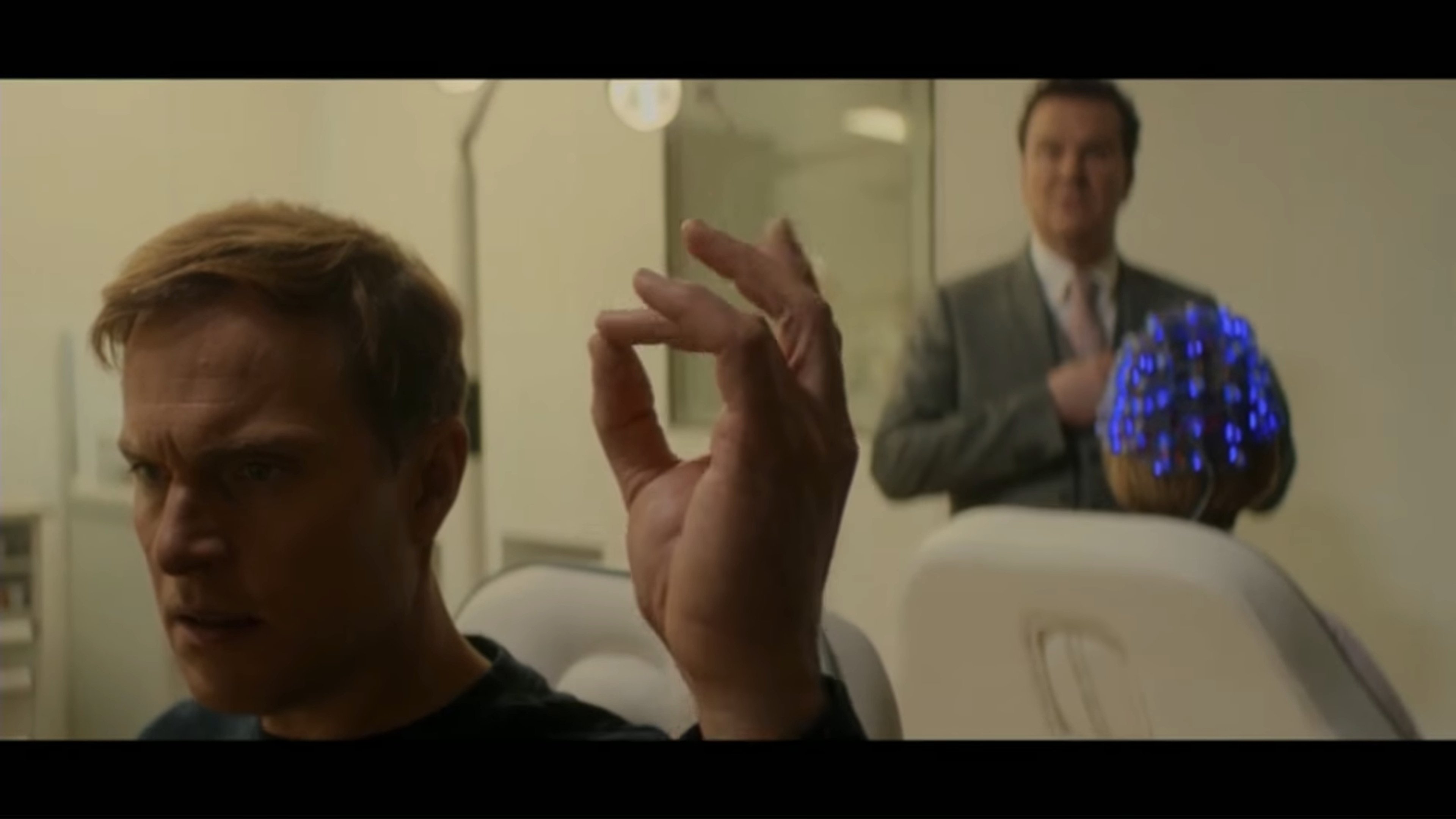 A middle-aged man in a white lab coat in a medical setting