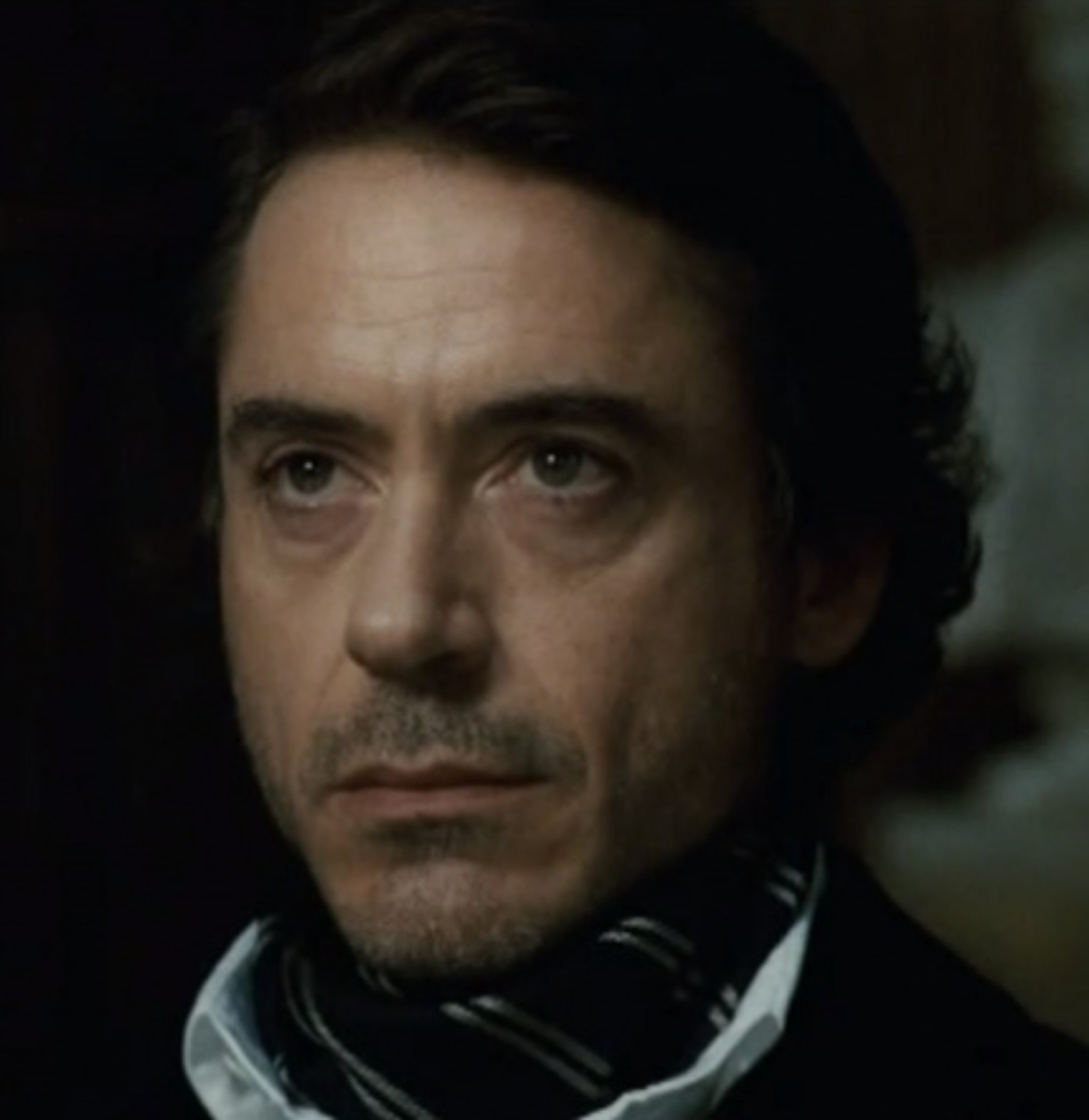 Portrait of a serious-looking middle-aged man in a suit and scarf