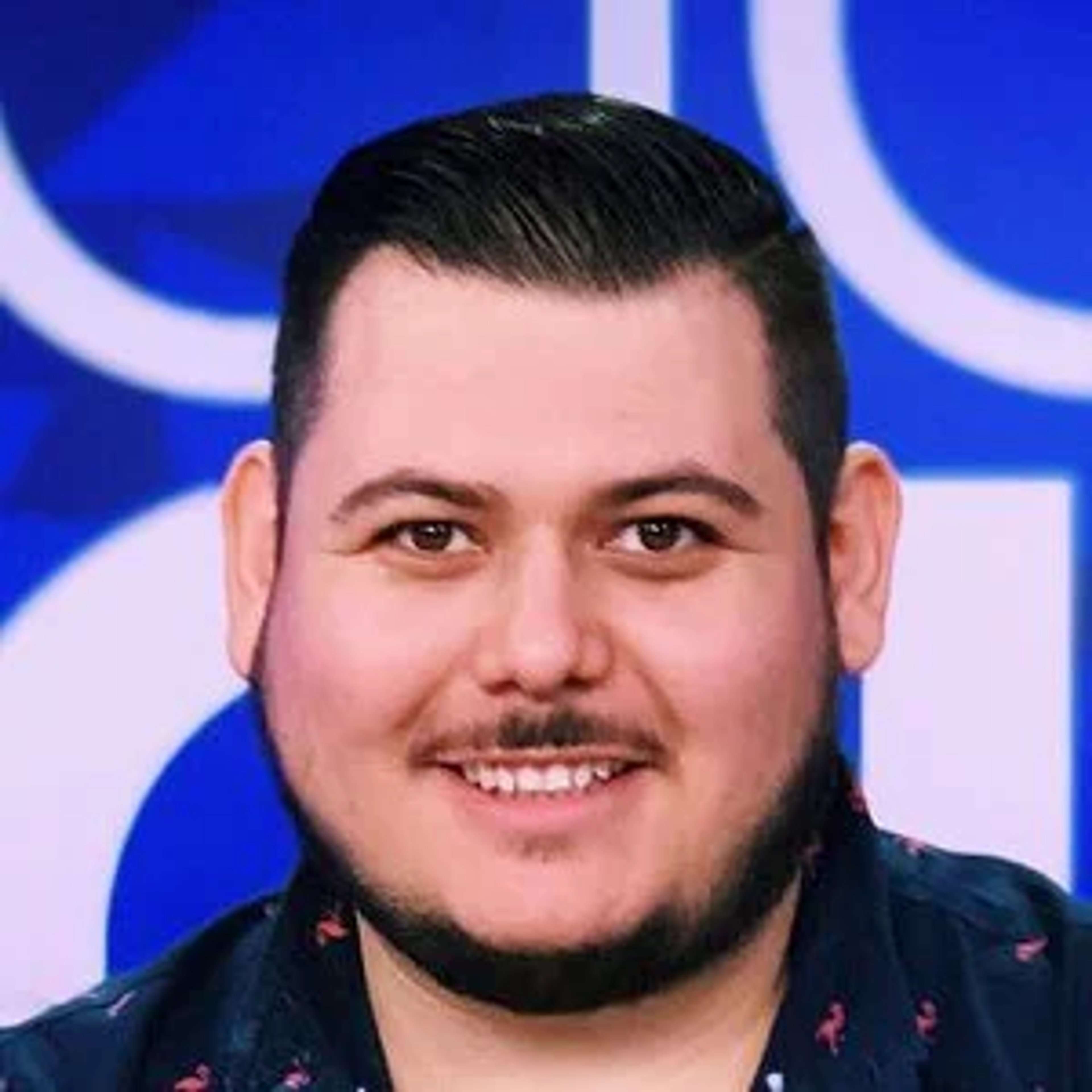 A middle-aged Hispanic man with a friendly expression