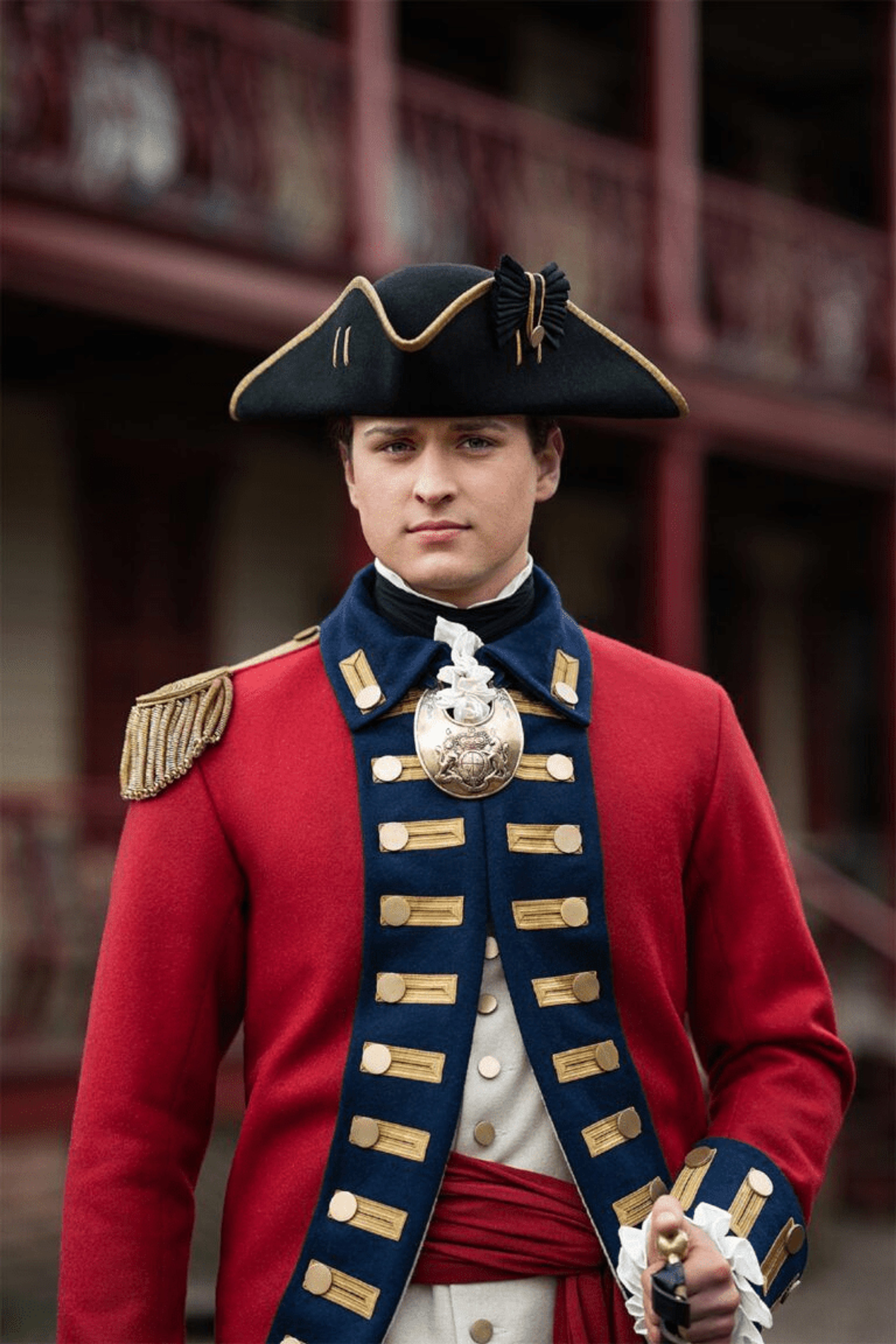 A man in a red military uniform with a black tricorn hat