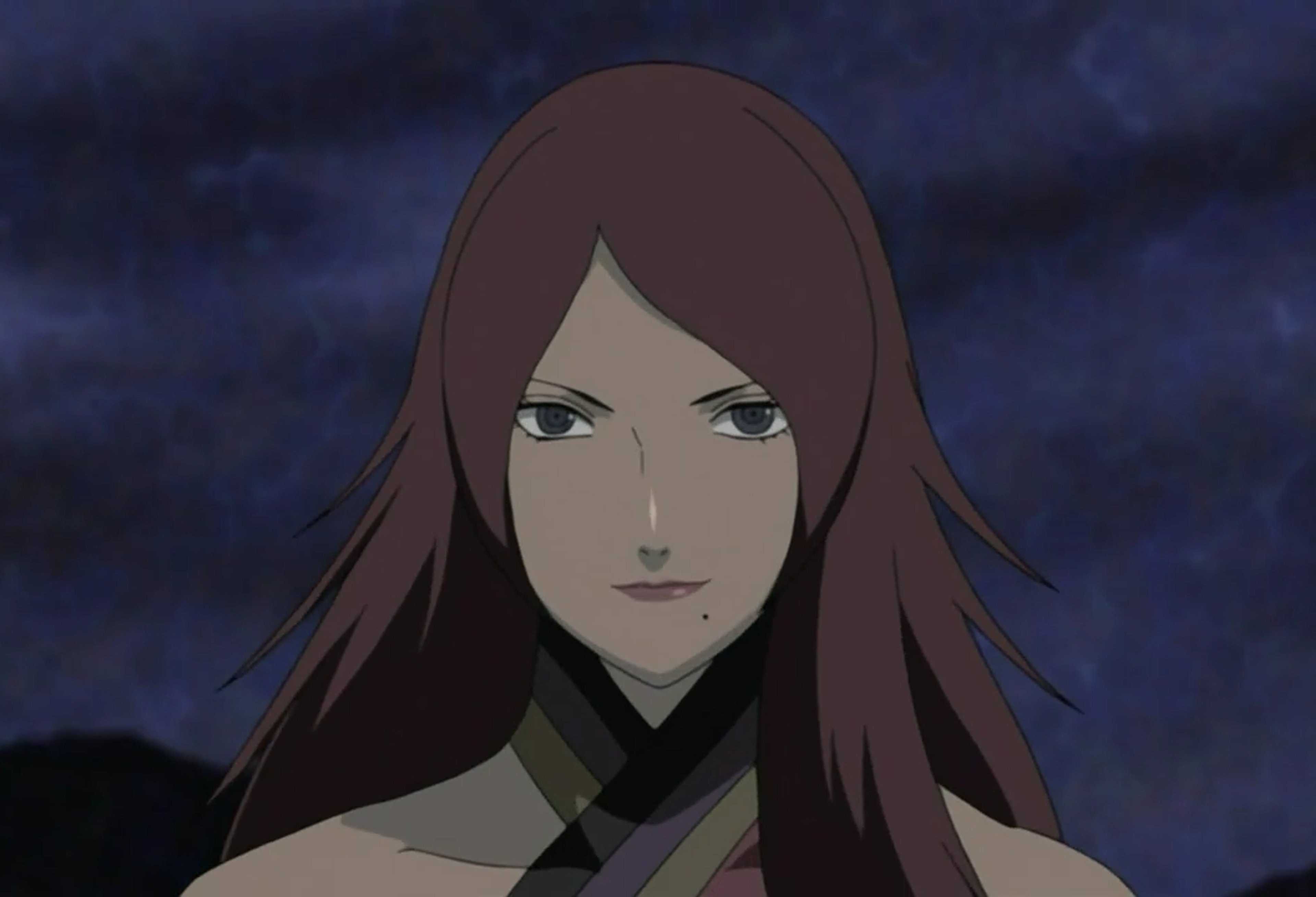 A young woman with long, dark red hair and a serious expression