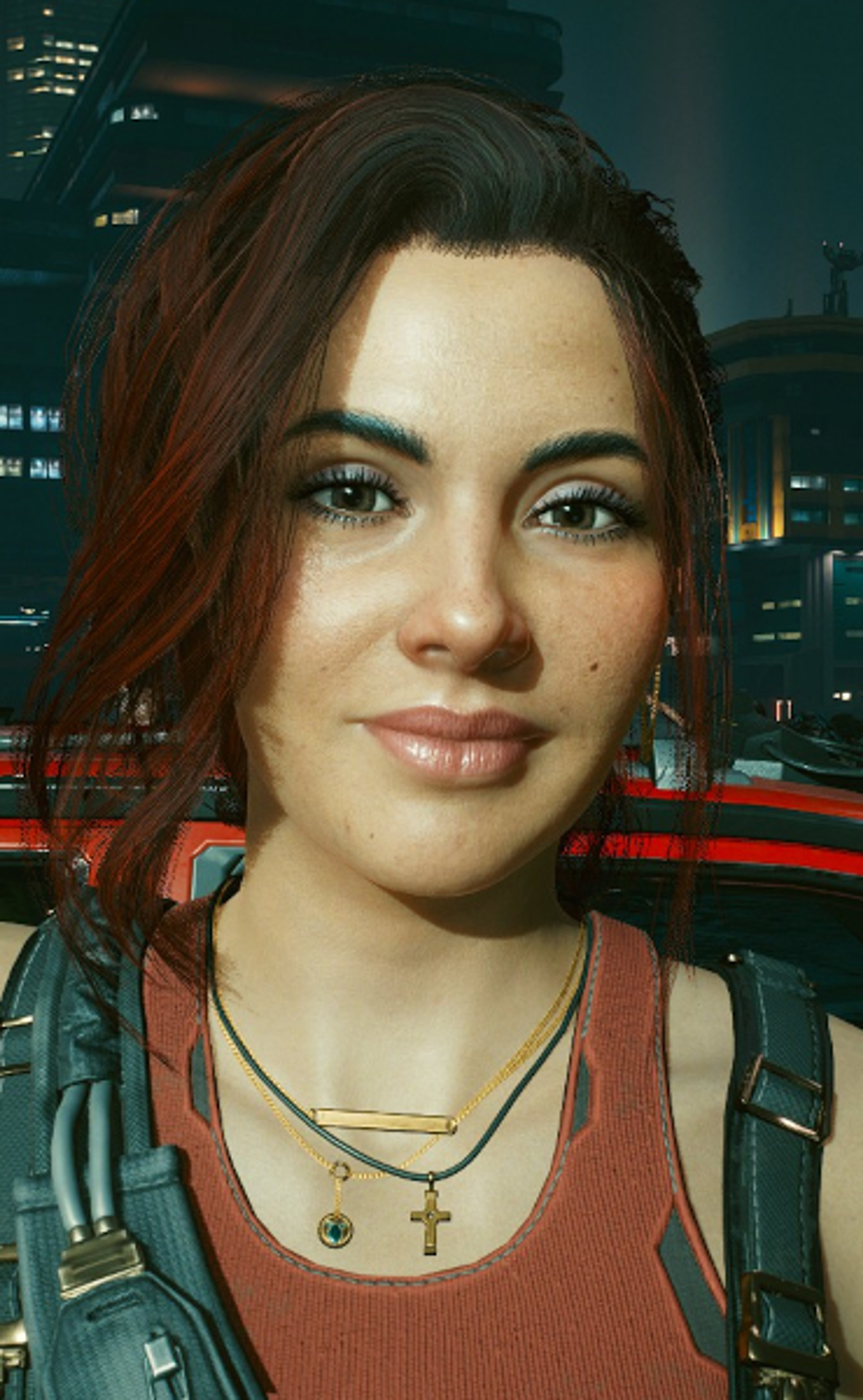 A woman with dark hair and a red top in a city setting