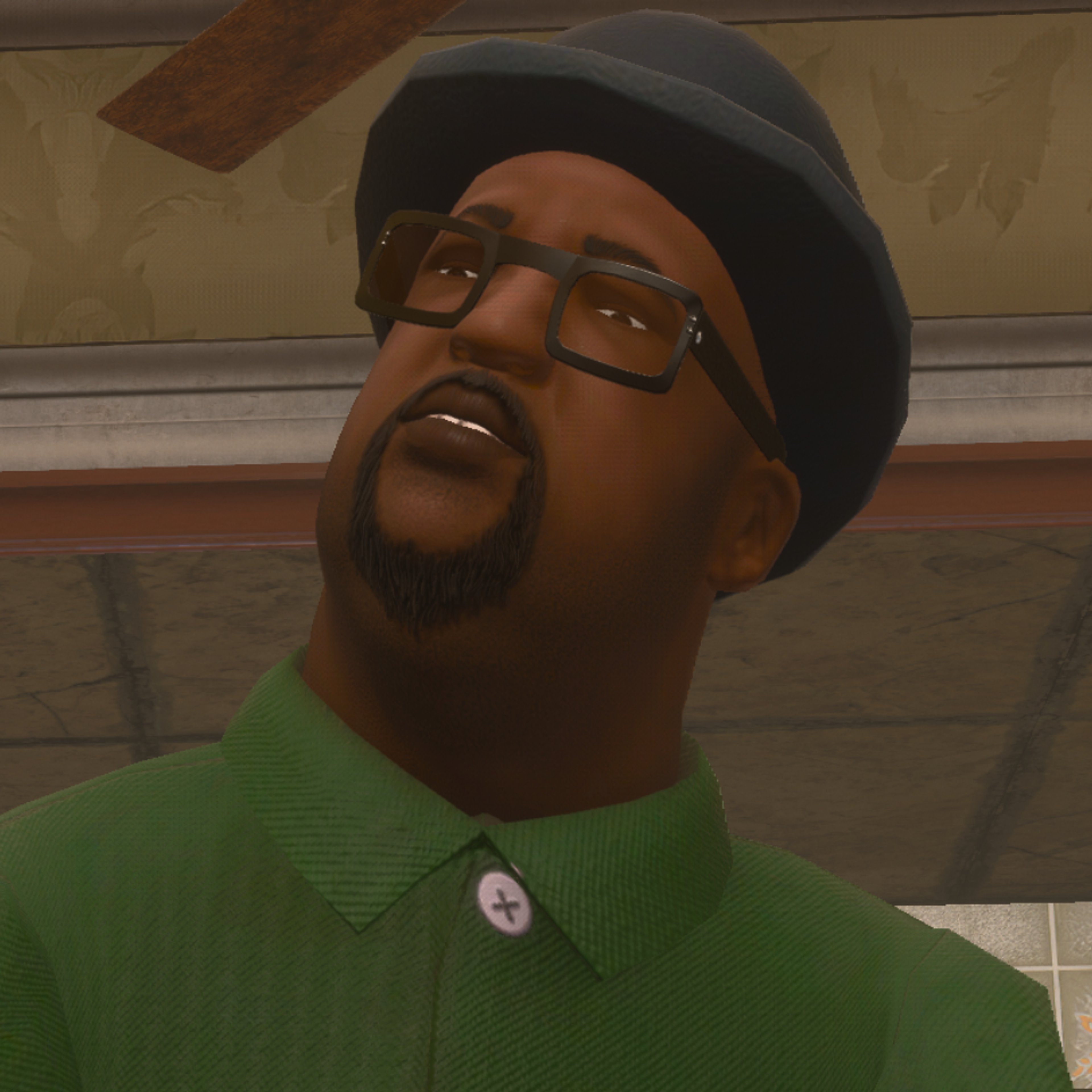 A Black man with a beard, glasses, and a black hat wearing a green shirt