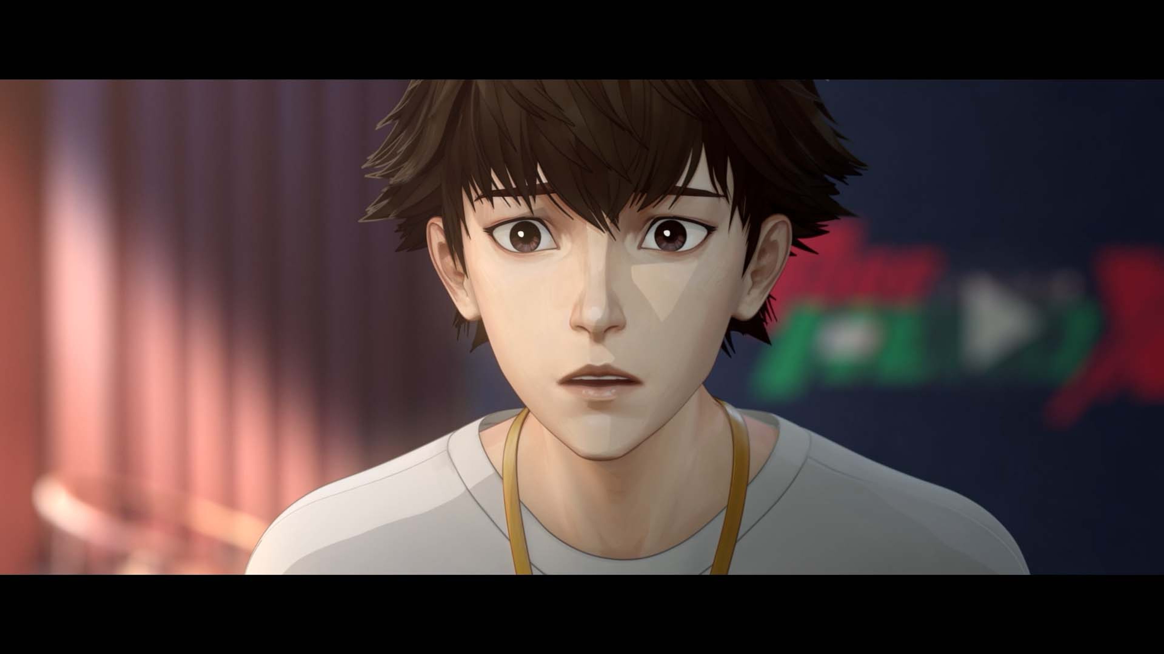 A young man with short, dark hair and blue eyes wearing a white shirt