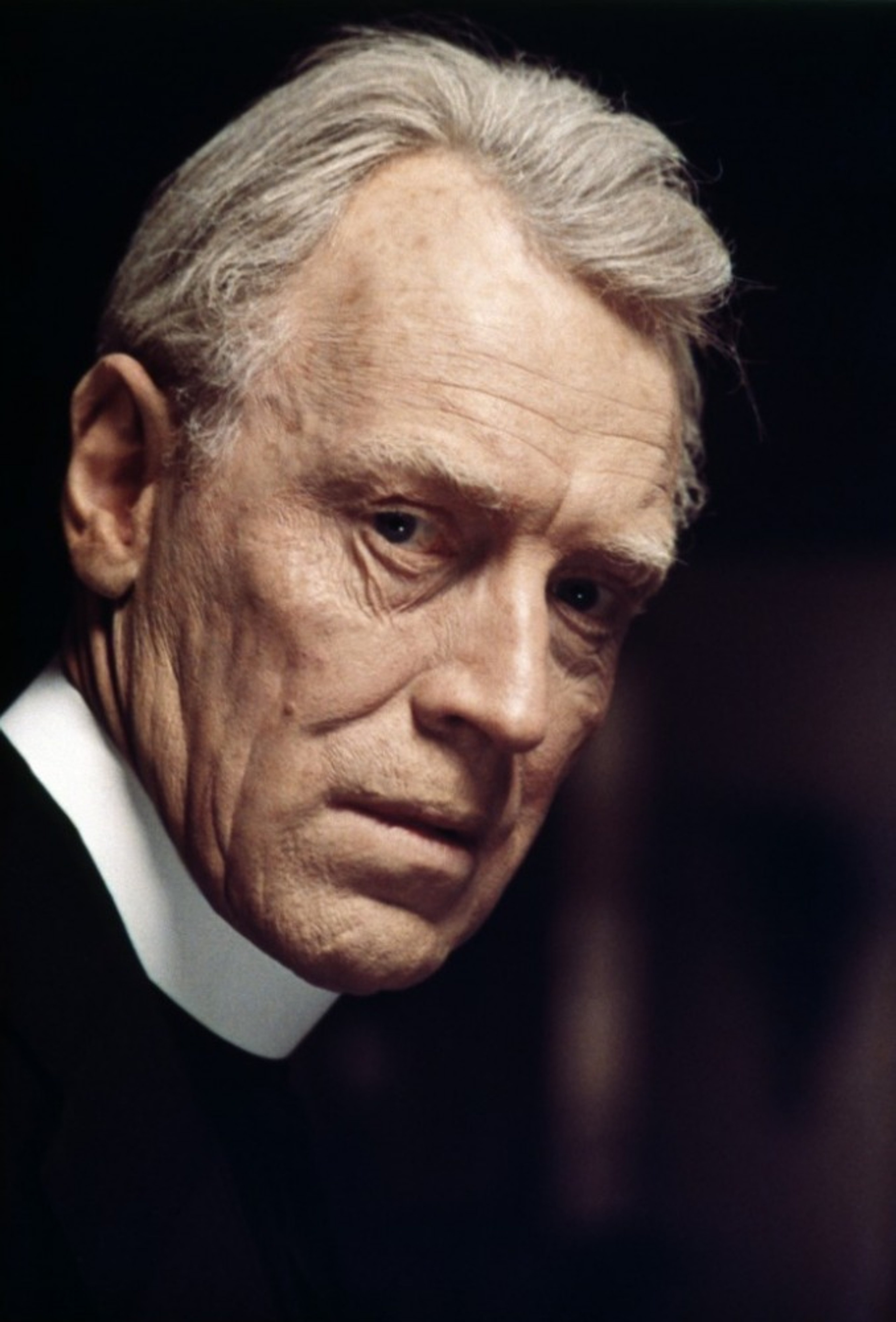 An elderly Catholic priest with a weathered face and intense expression