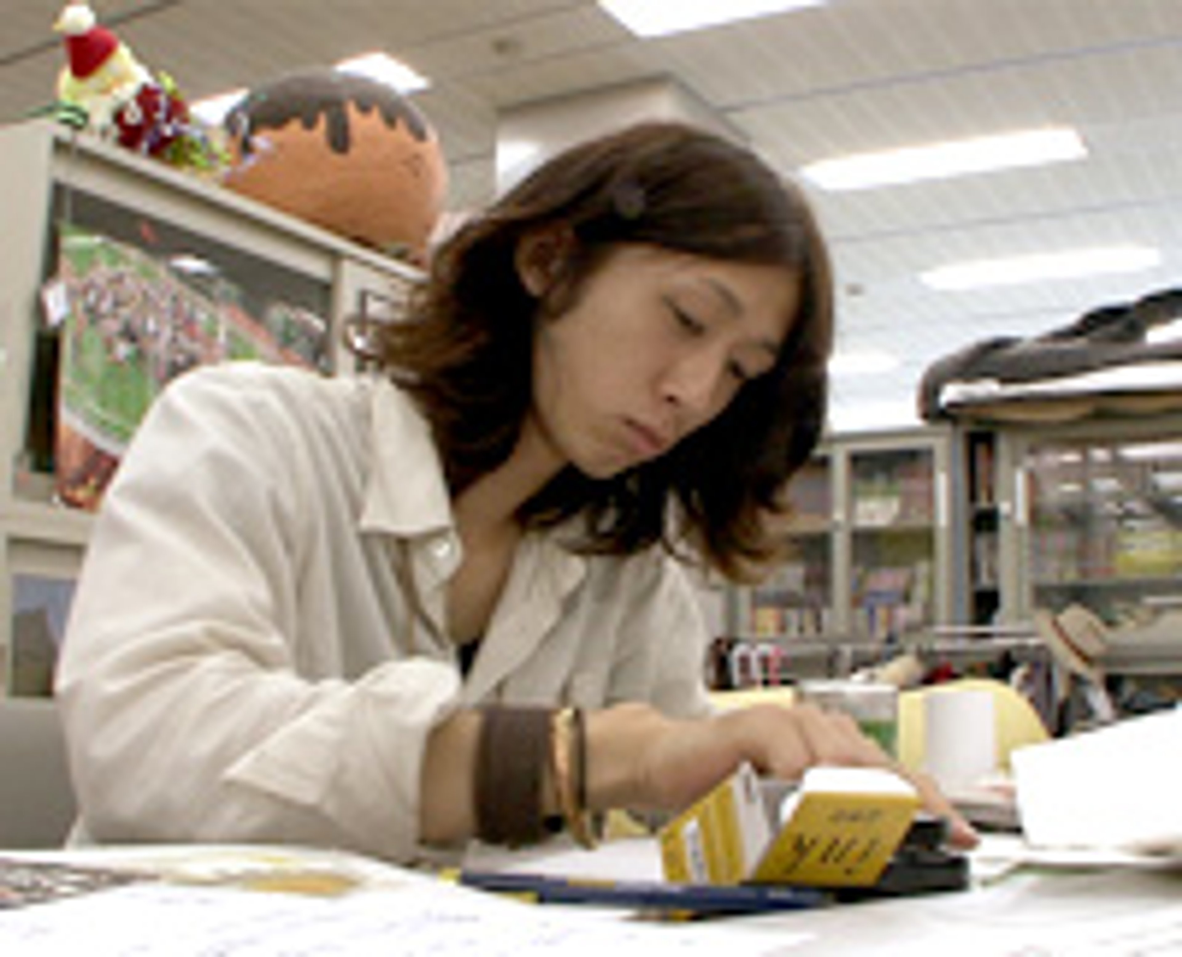 A young man sitting at a desk, focused on something in front of him.