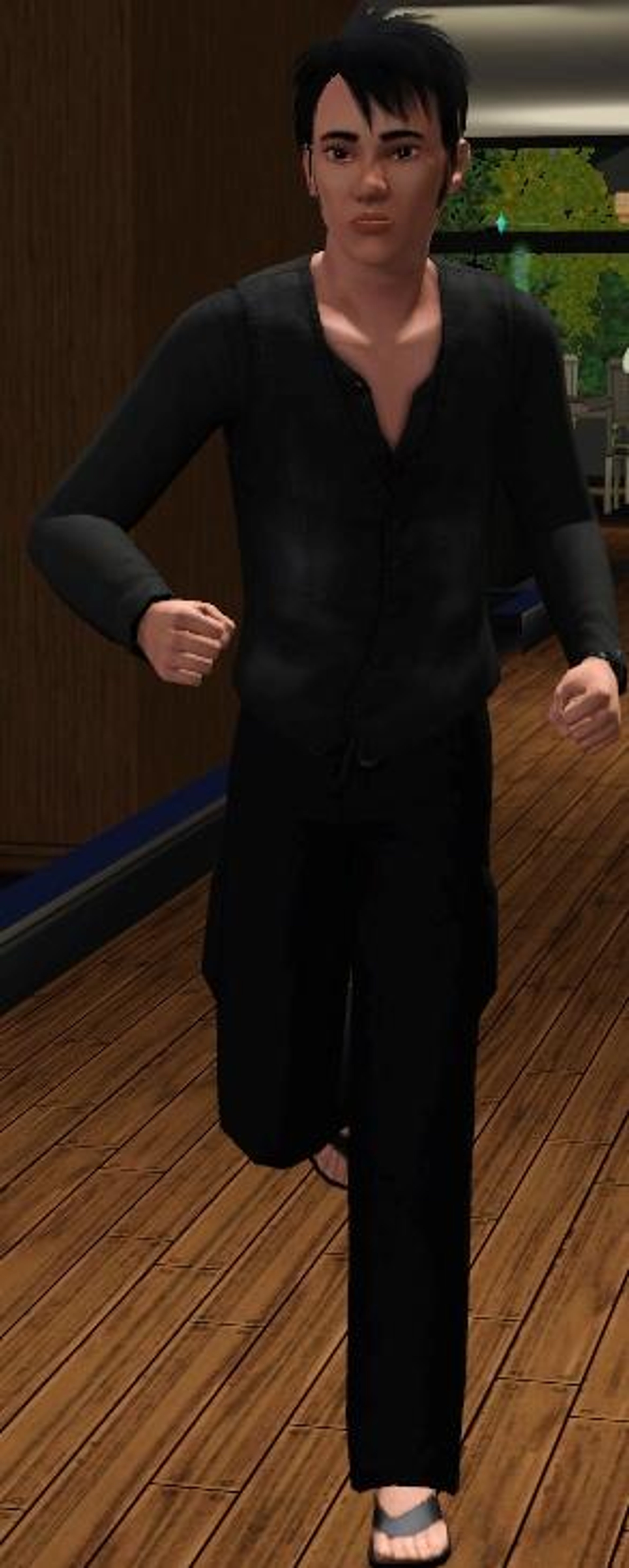 A young man in a black outfit standing in a room