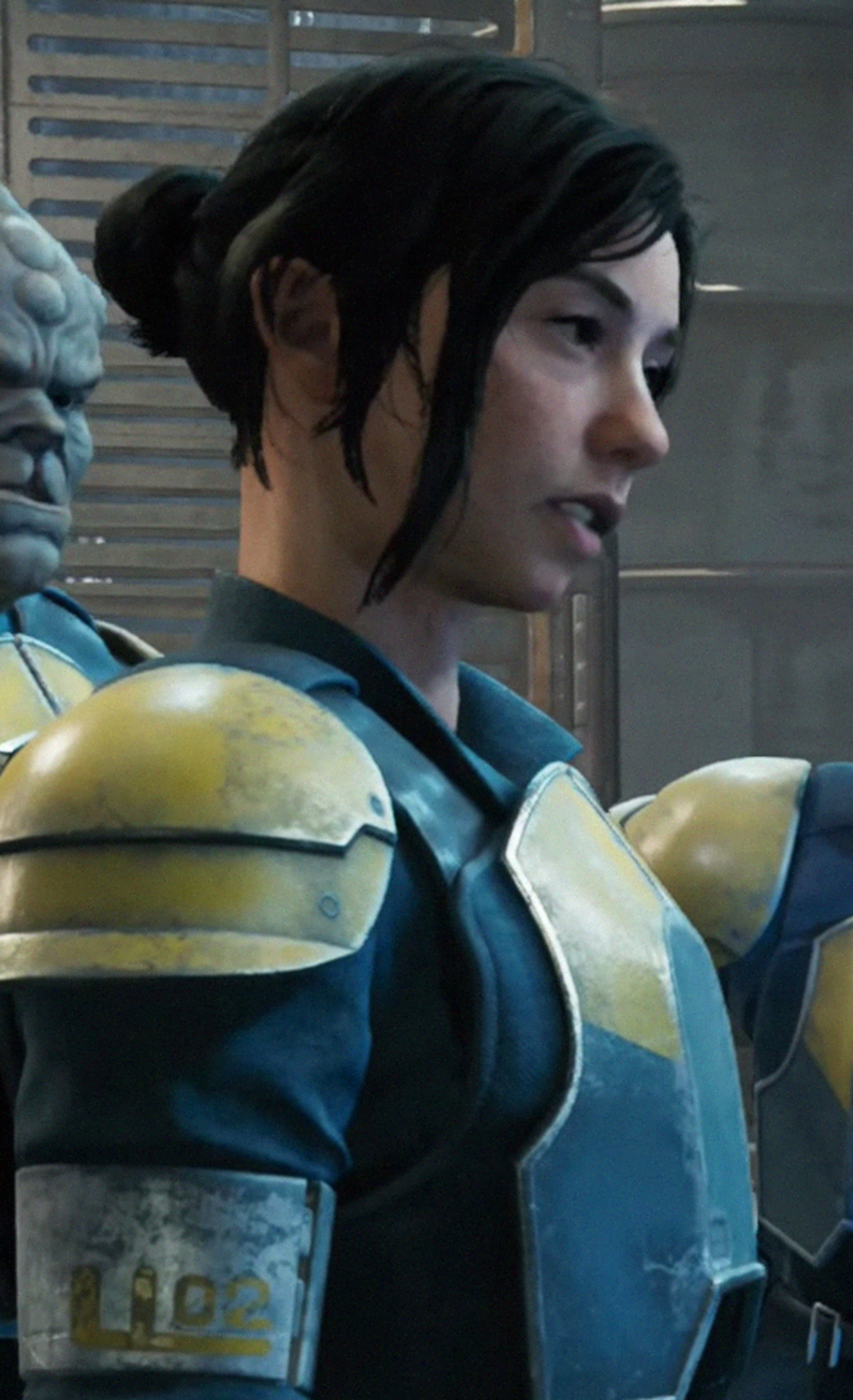 A young woman with dark hair wearing a blue and yellow outfit with armor-like elements