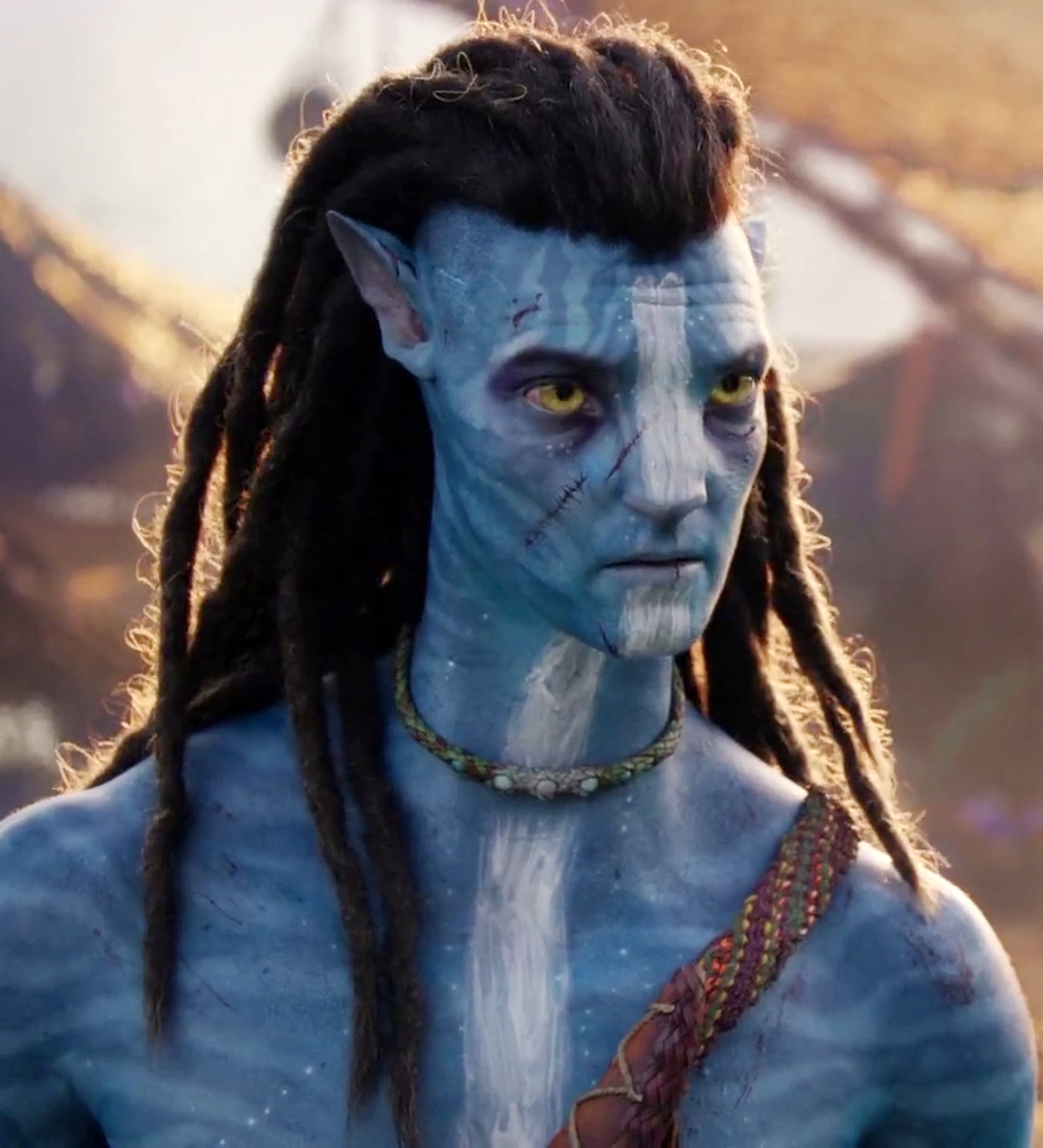 A blue-skinned humanoid character with dreadlocks and tribal jewelry in a natural outdoor setting