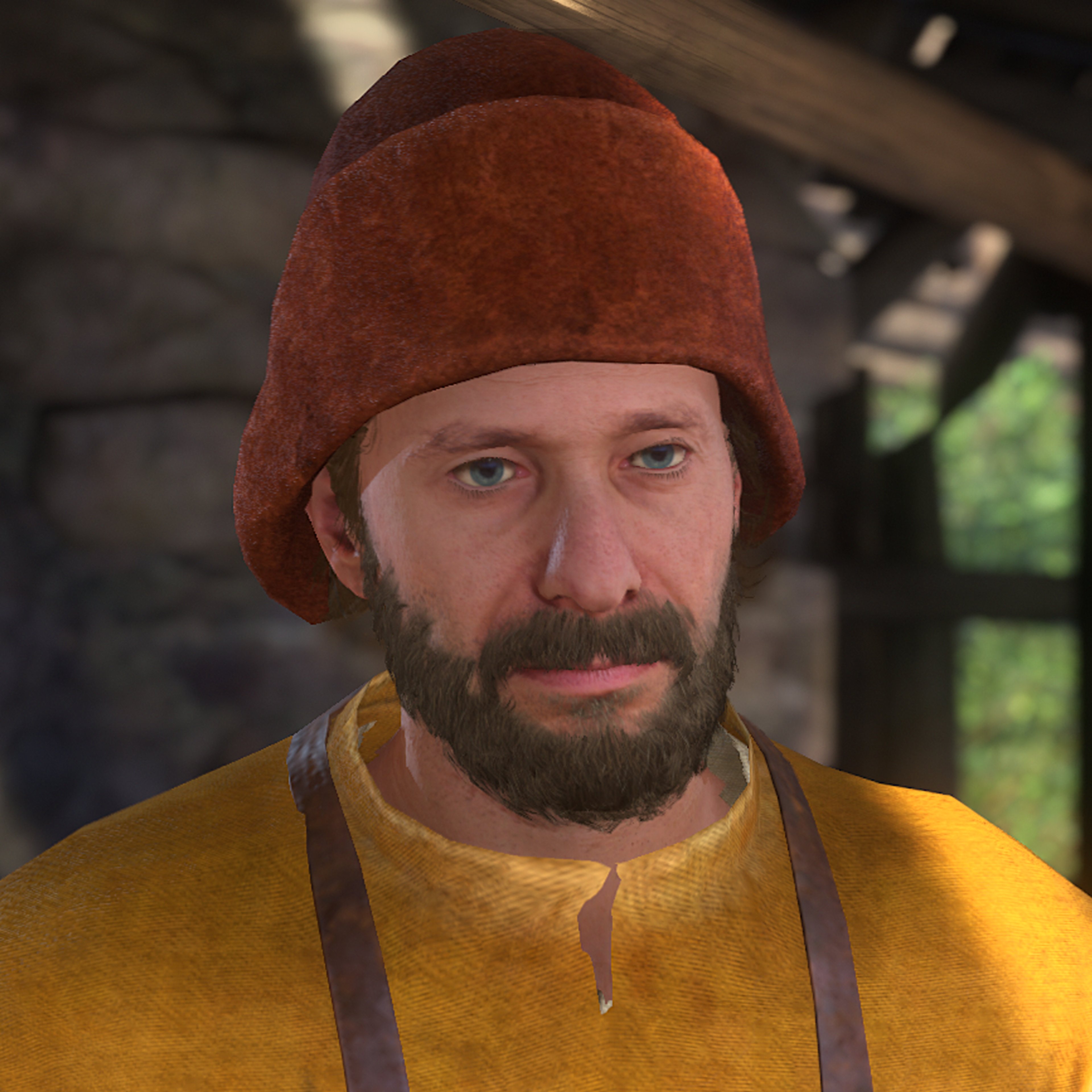 A middle-aged man with a beard and mustache, wearing a red hat and yellow jacket, with a serious expression on his face.