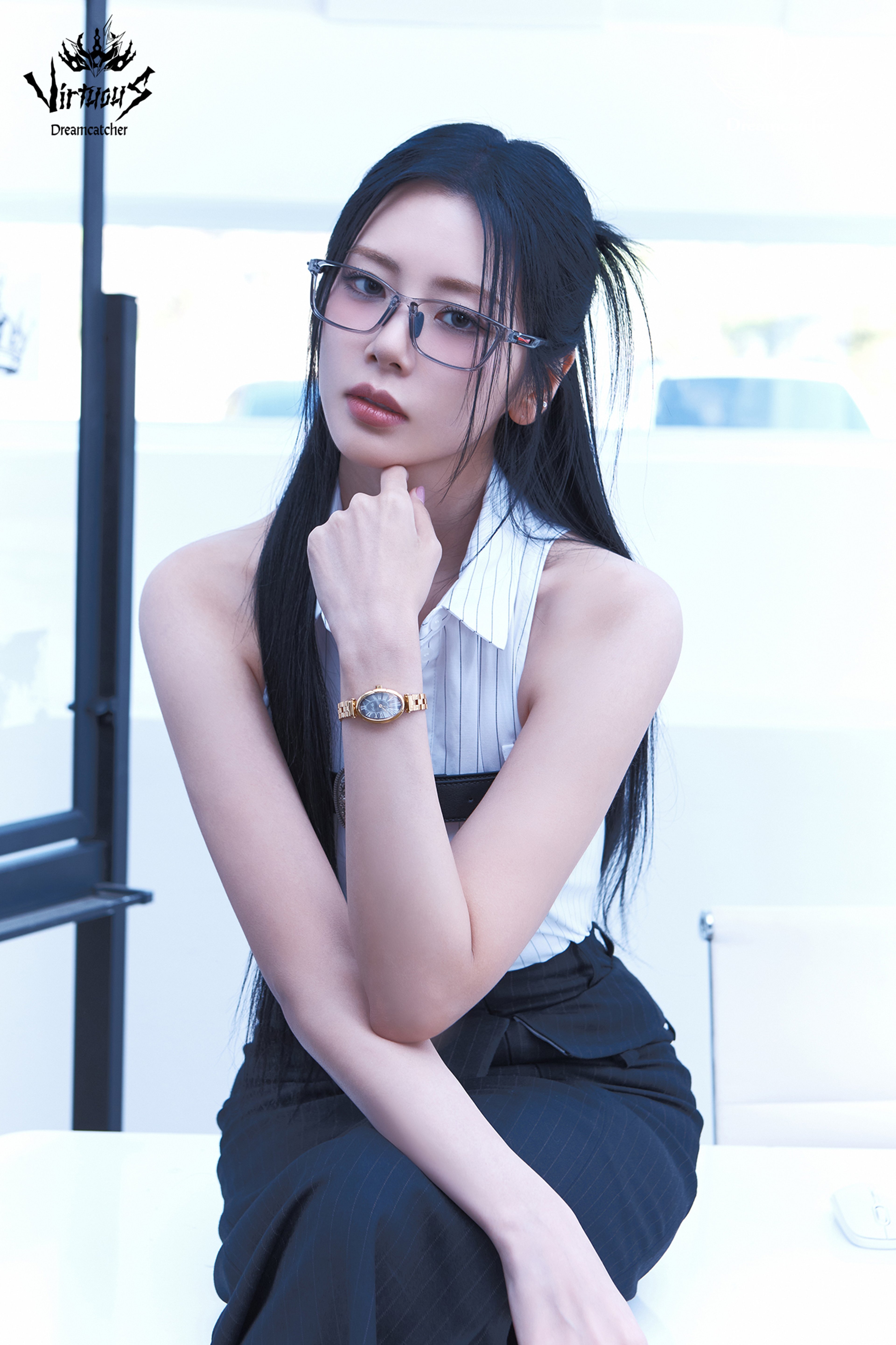 A young woman with dark hair and glasses looking directly at the camera.