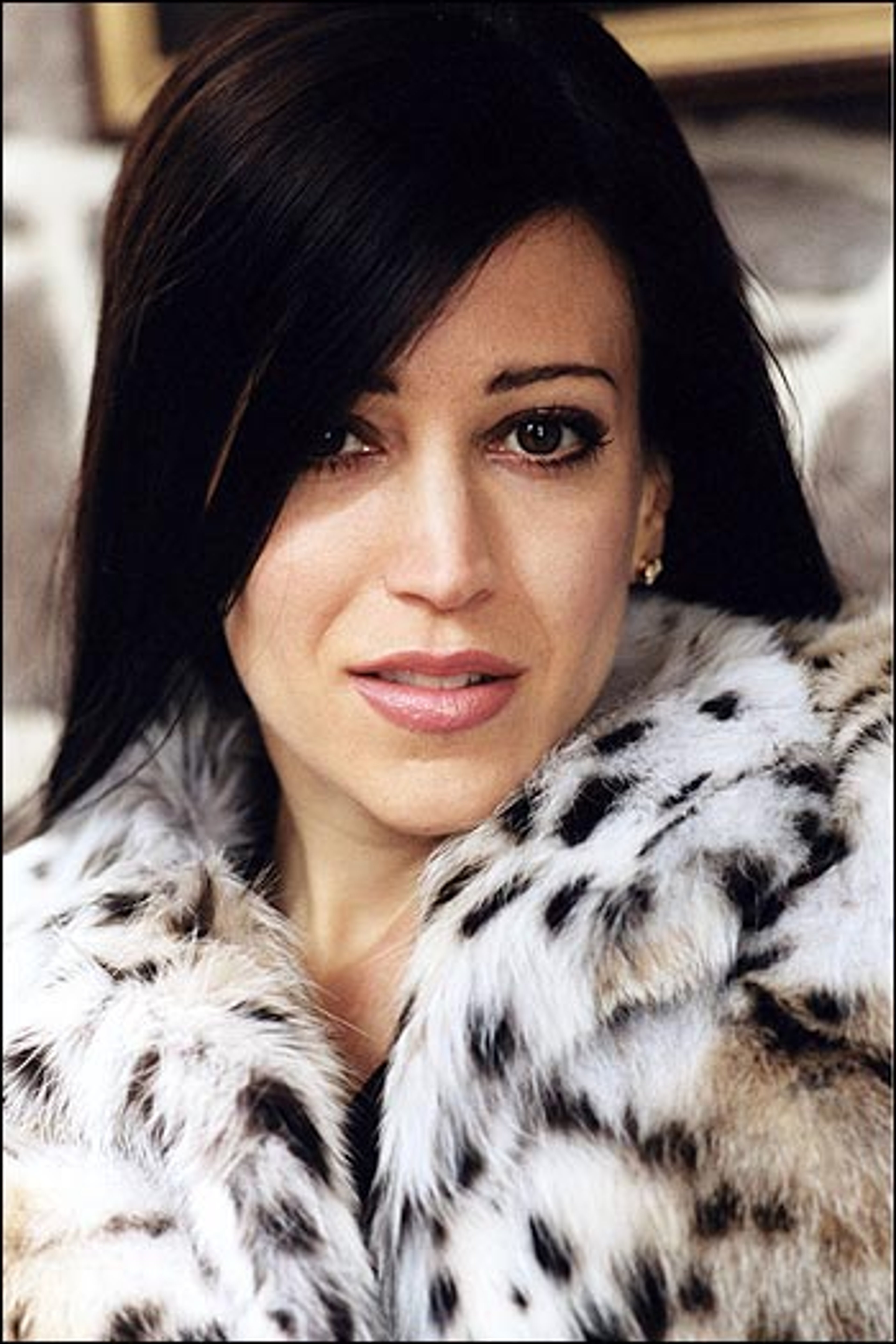 A woman with dark hair wearing a fur coat