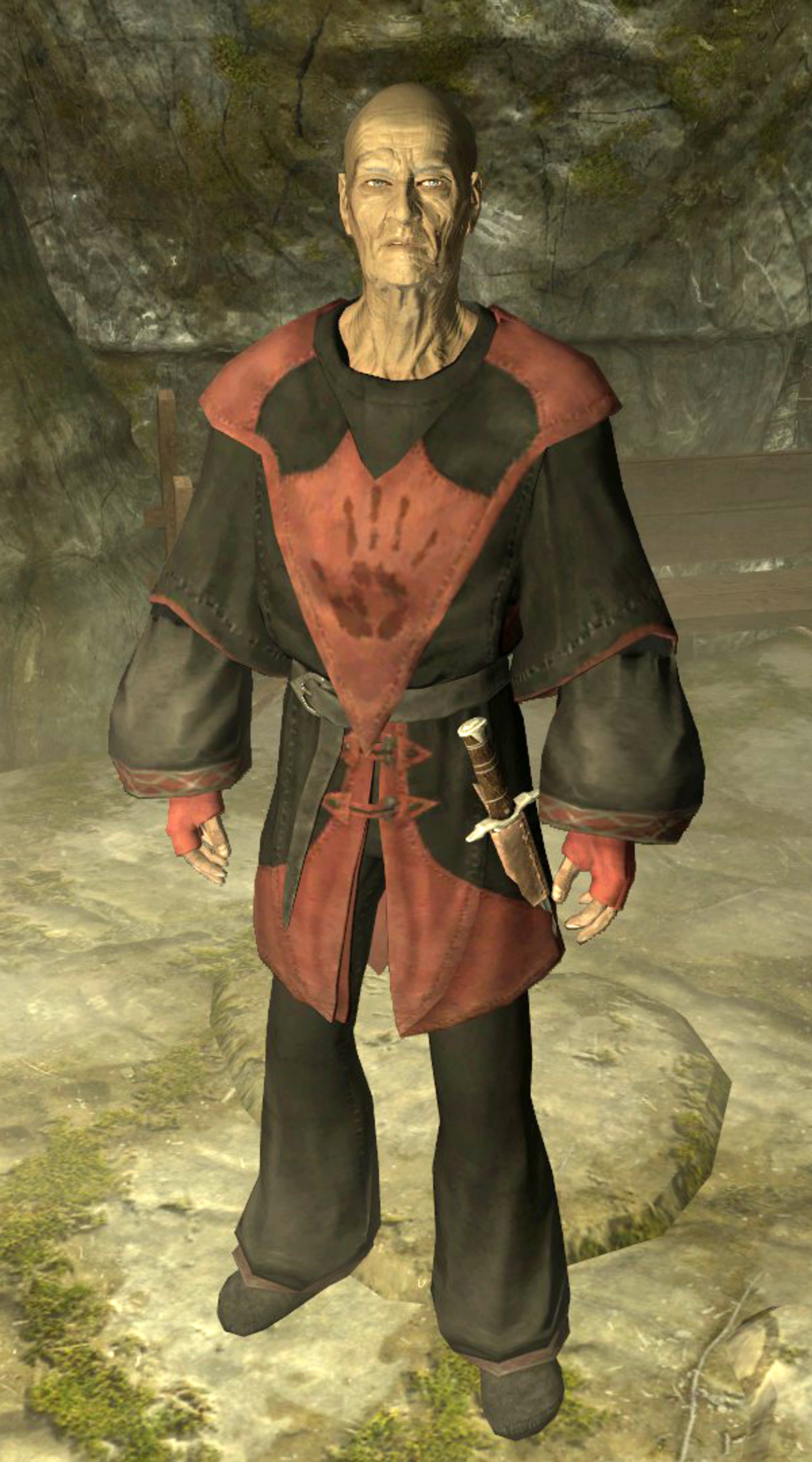 An elderly man in a red and black robe holding a staff or wand, with a stern expression on his face.