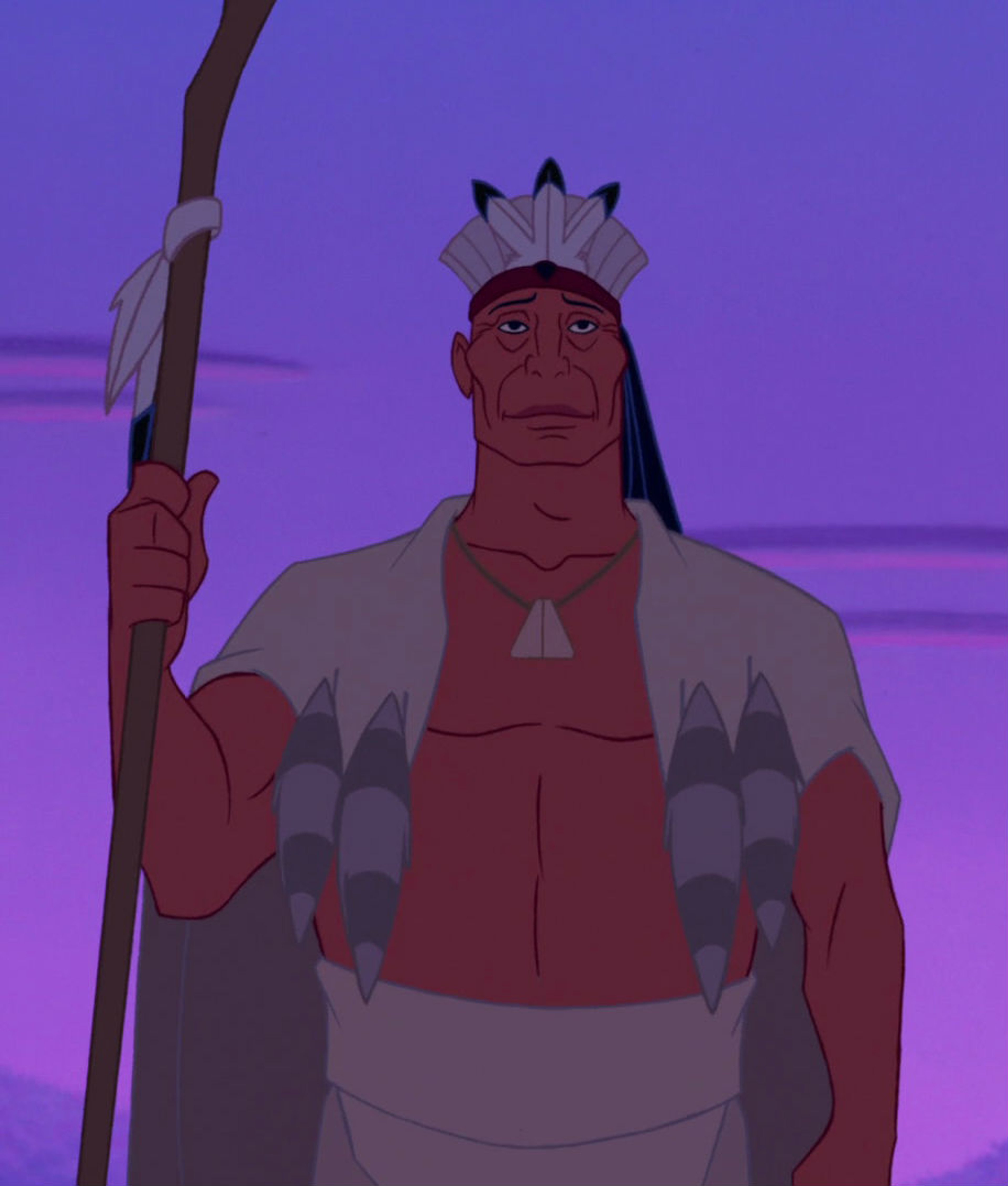 An older Native American man wearing a headdress and traditional clothing, holding a staff or spear.