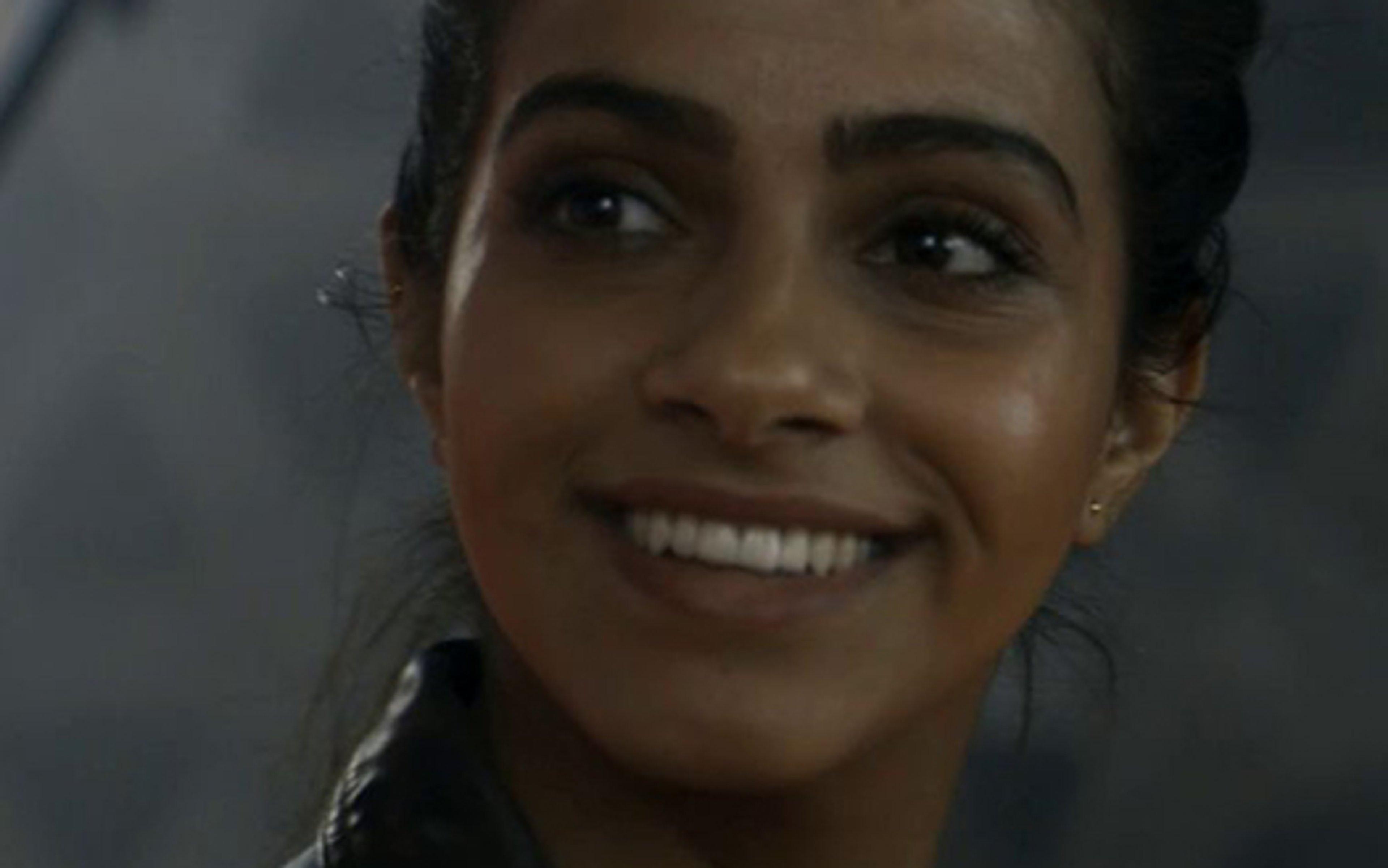 A smiling young woman in a police uniform