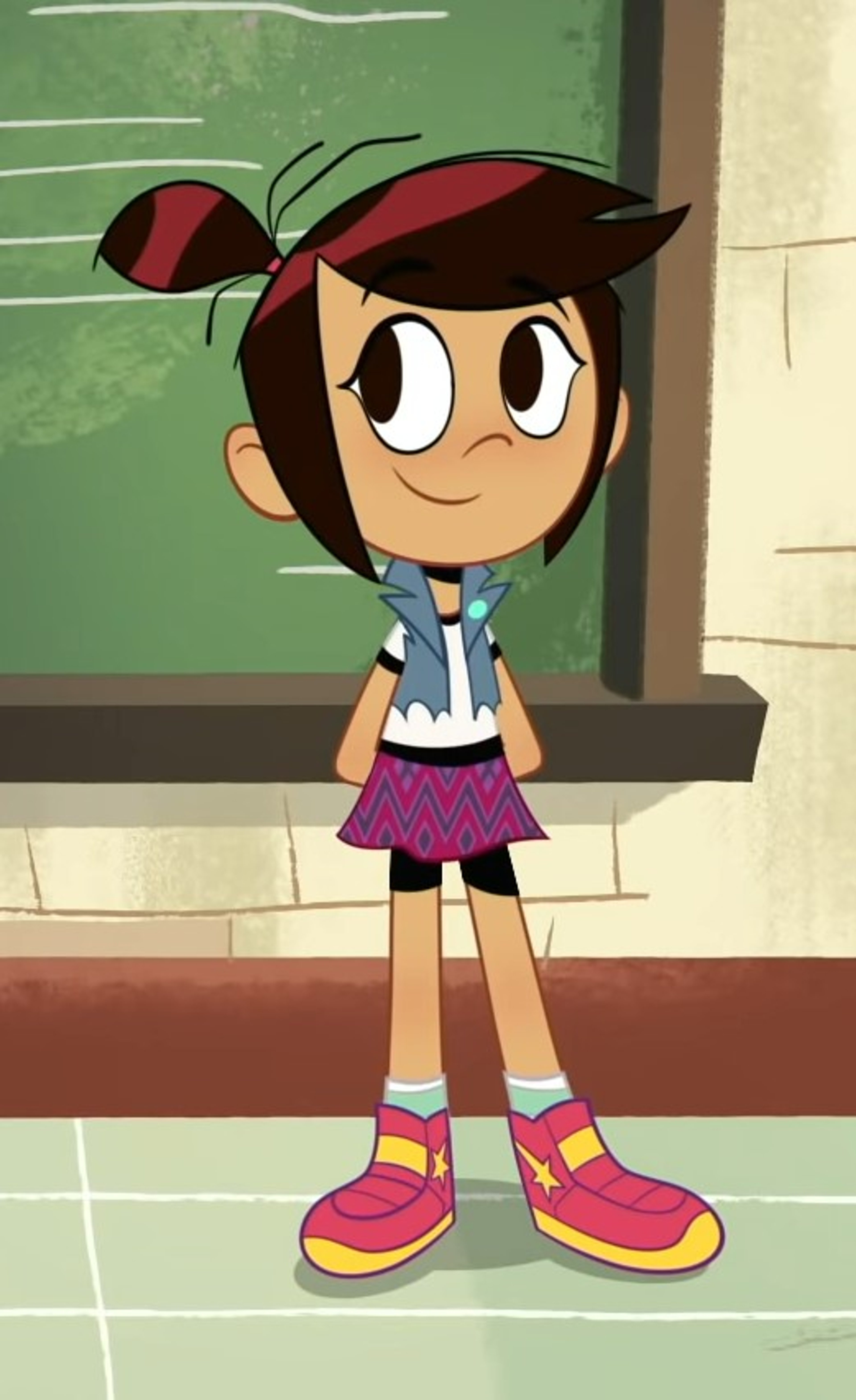 A young girl with brown hair in a ponytail, wearing a blue shirt, purple skirt, and red shoes, standing in front of a green background.