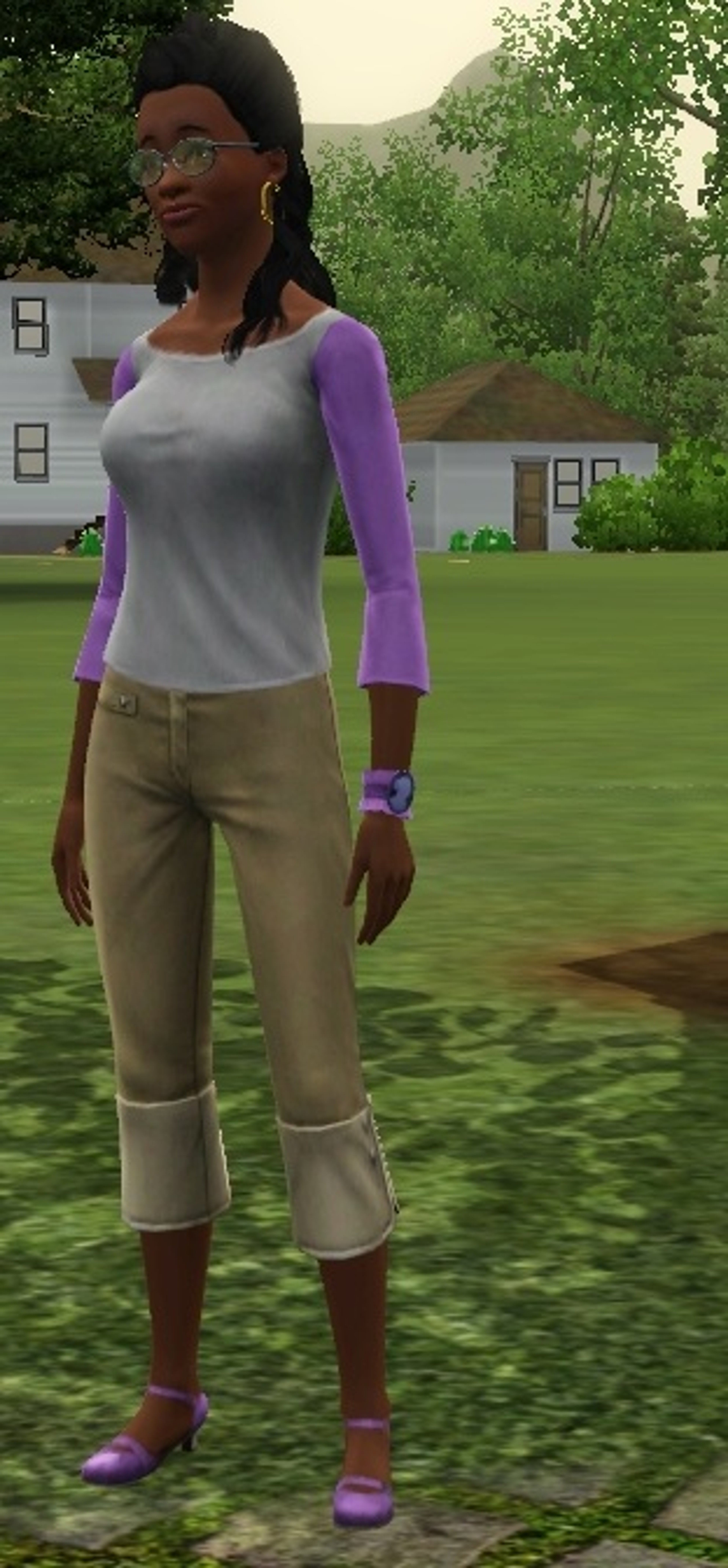 A young woman with dark skin, grey eyes, and black hair in braids, wearing a white shirt with purple sleeves and tan pants, standing in a grassy outdoor setting.