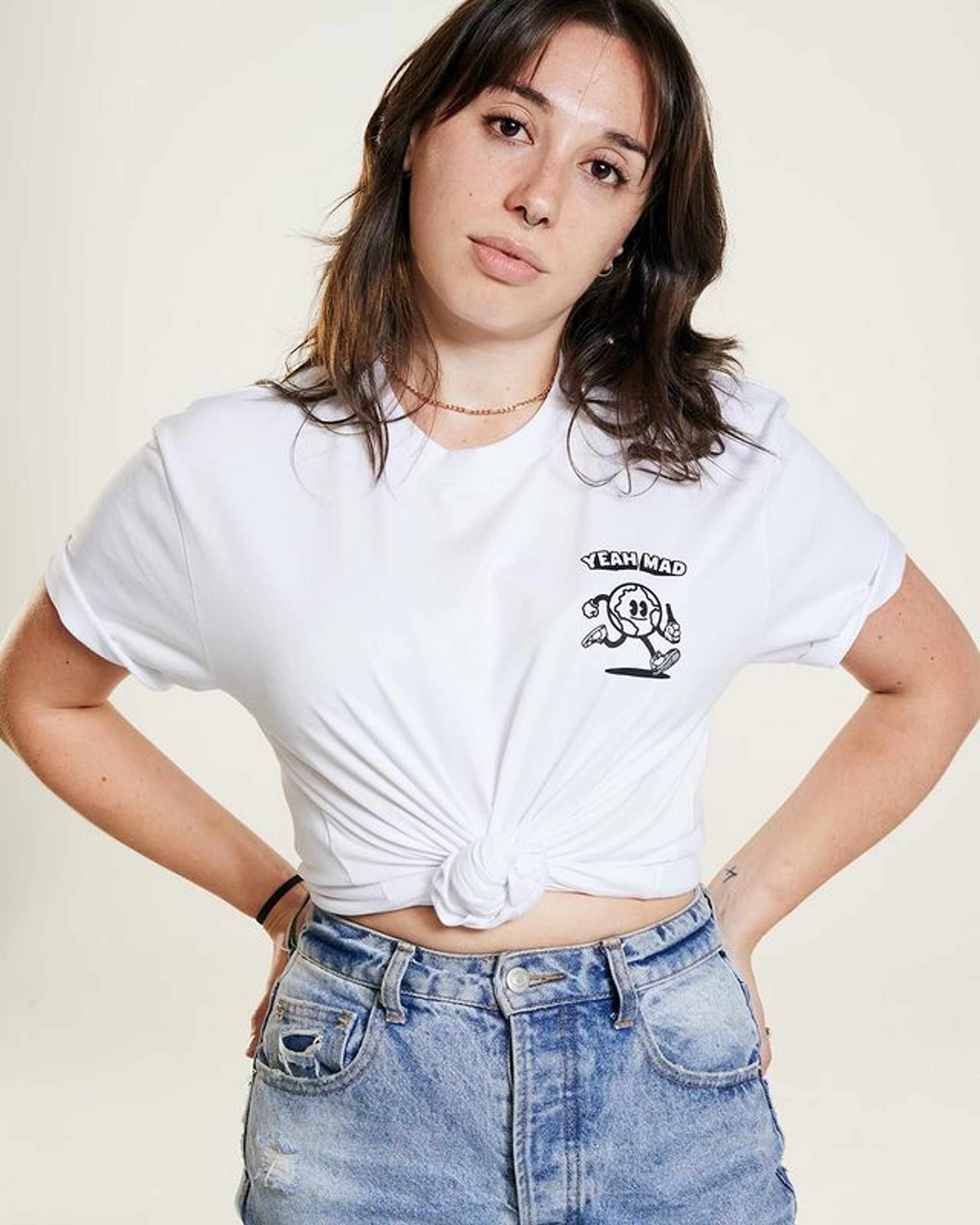 A young woman with long brown hair wearing a white t-shirt