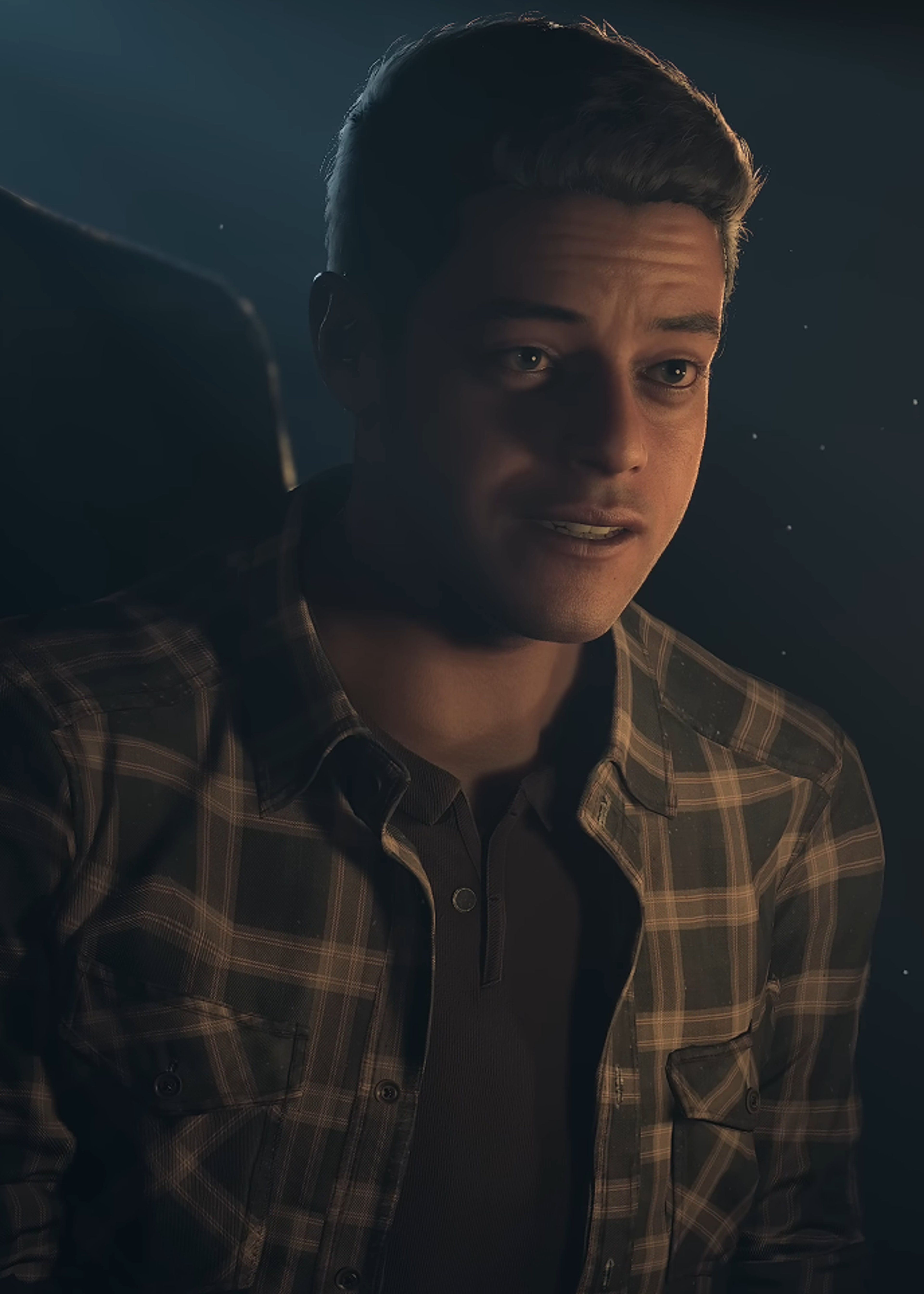 A young man with a serious expression in a dark, moody setting