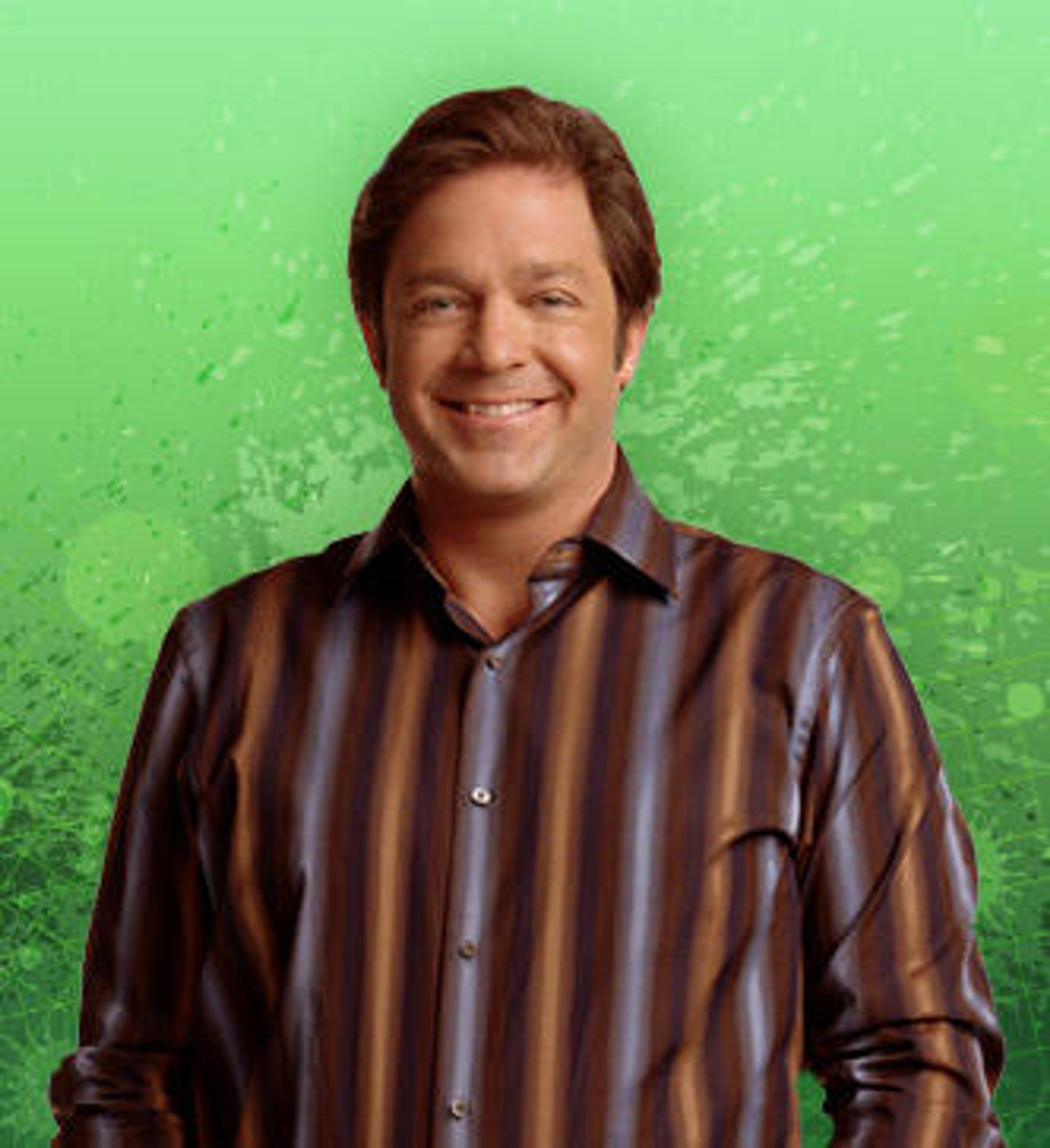 A middle-aged man with brown hair smiling in a studio setting