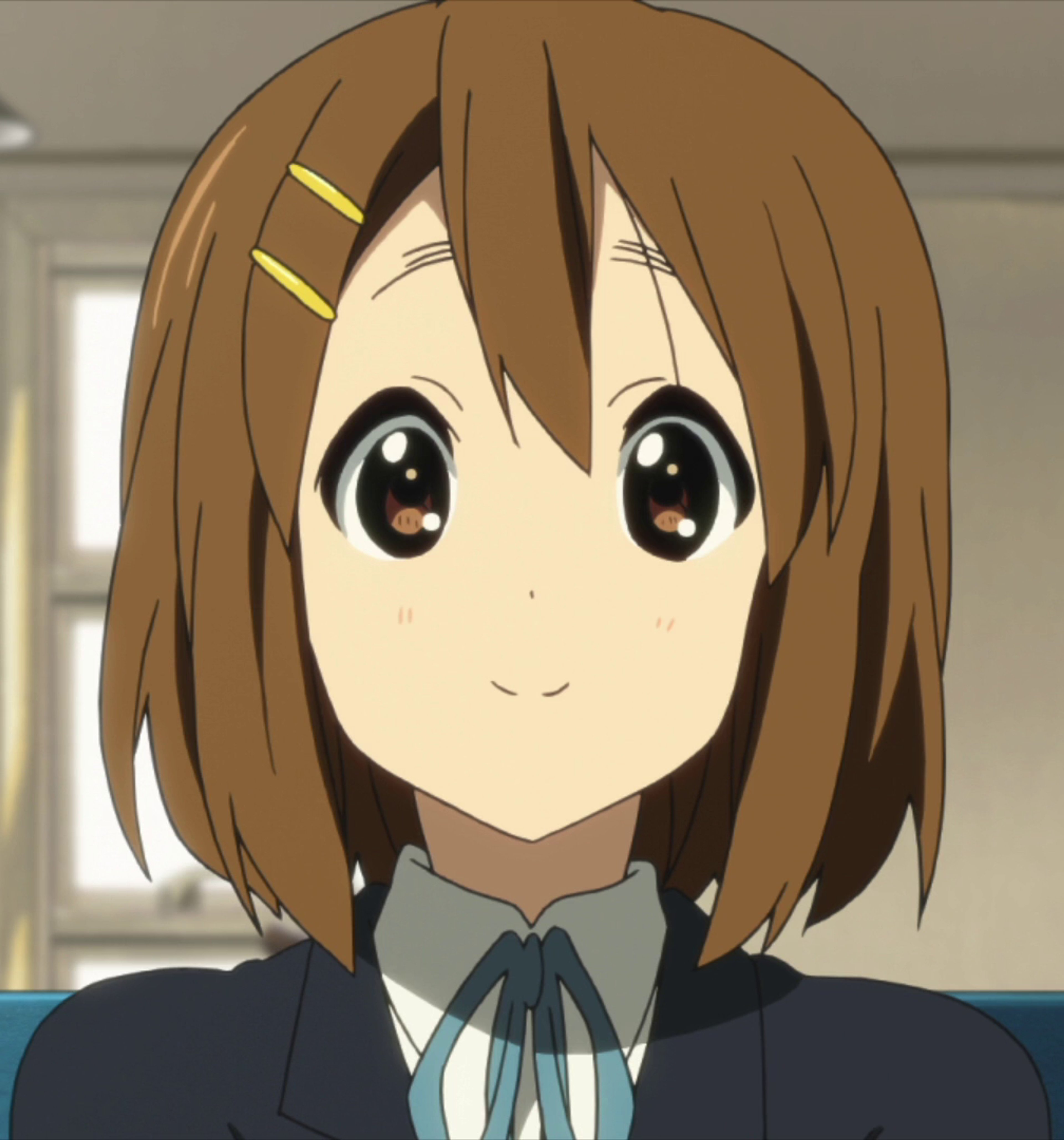 An anime-style illustration of a young, brown-haired girl in a school uniform