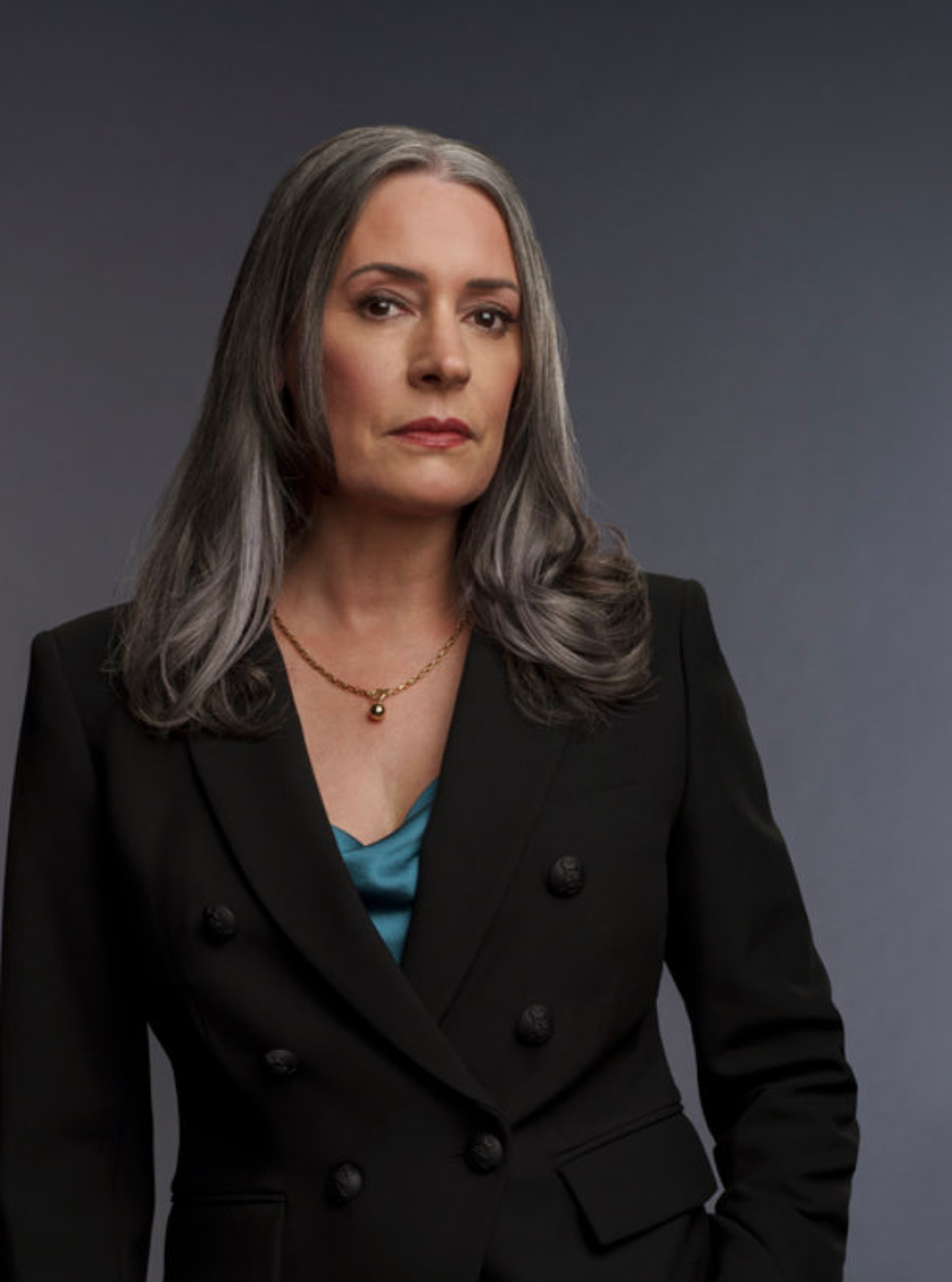 A middle-aged woman with gray hair wearing a black suit jacket