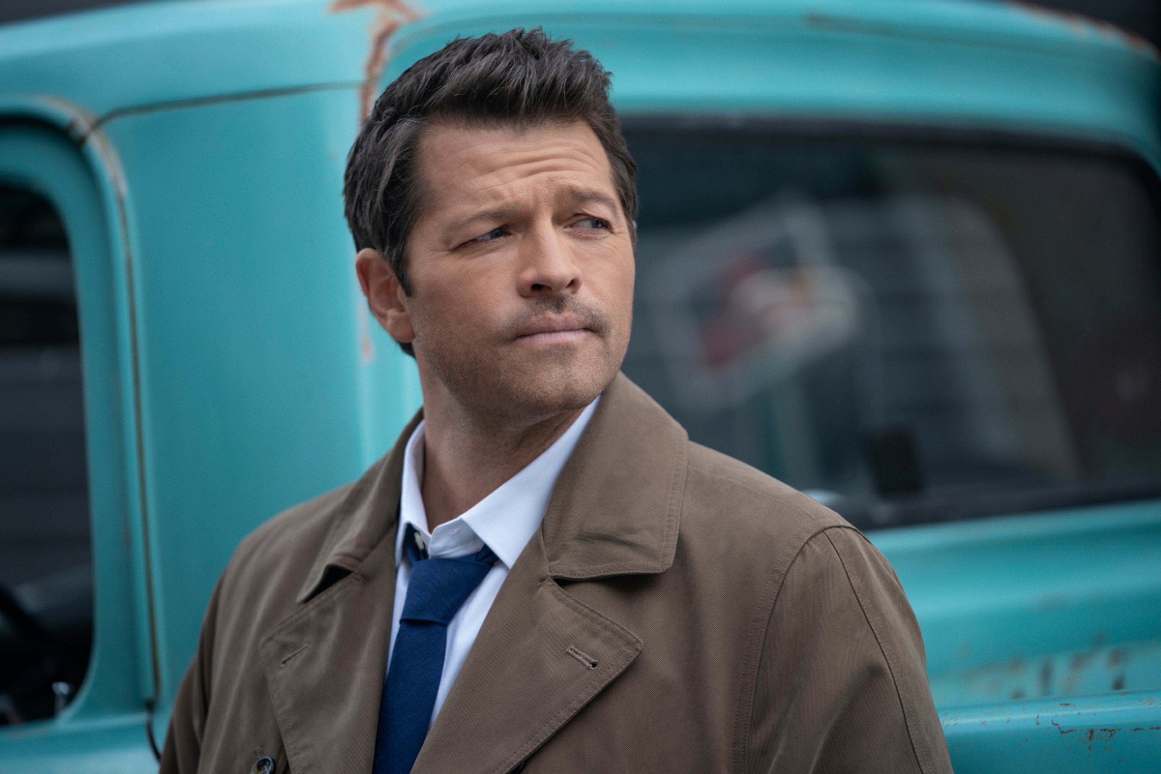 A man in a trenchcoat with a serious expression