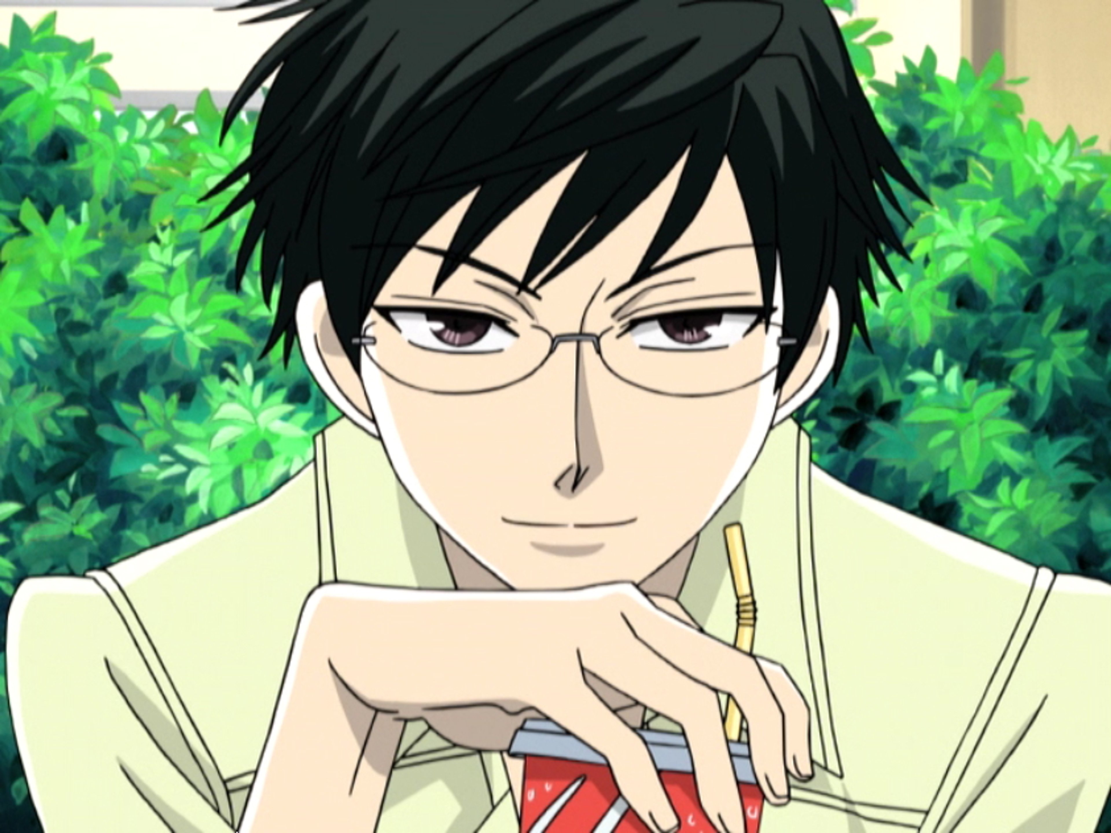 A young man with dark hair and glasses wearing a light-colored shirt