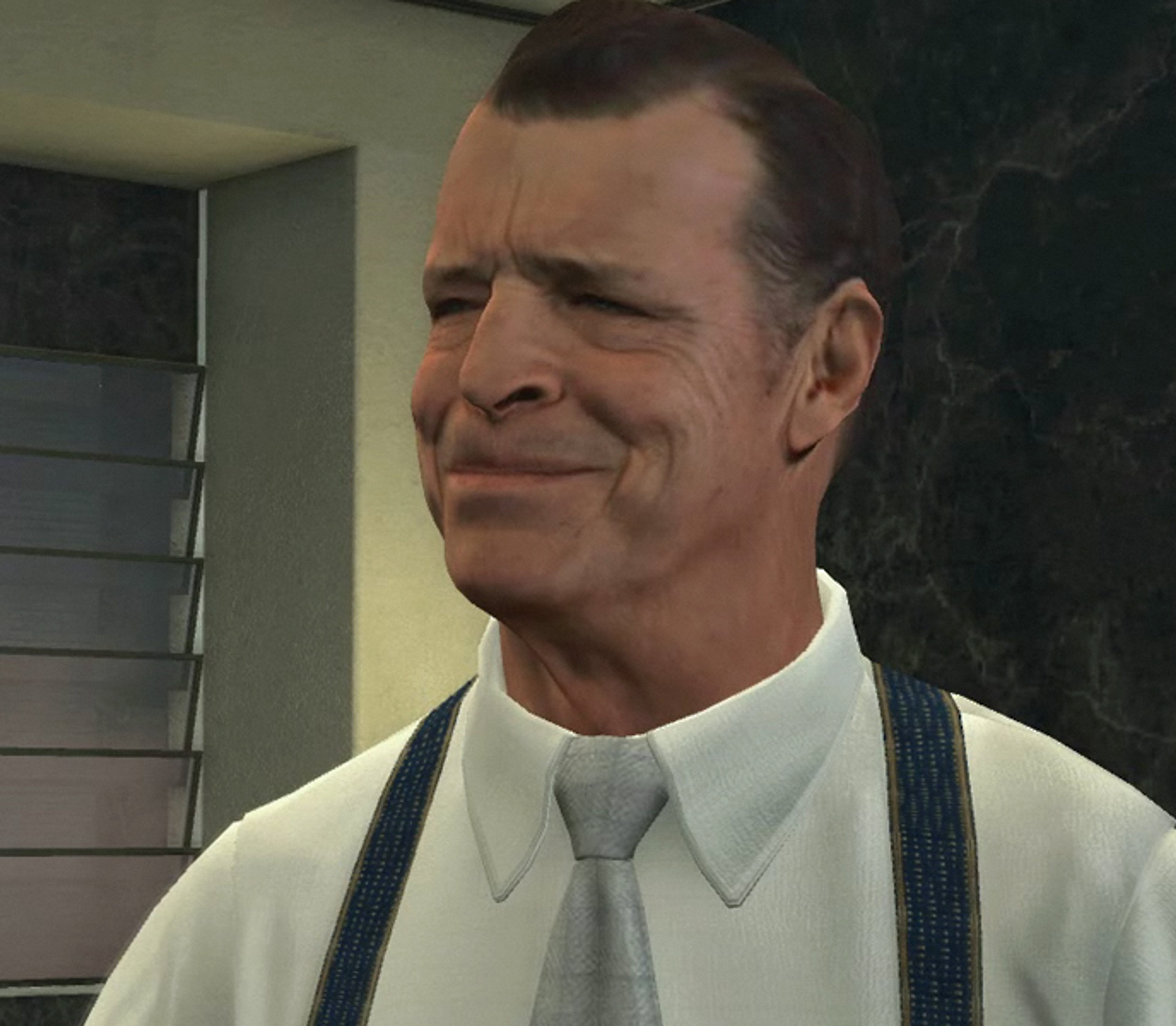 A middle-aged man in a suit with a stern expression