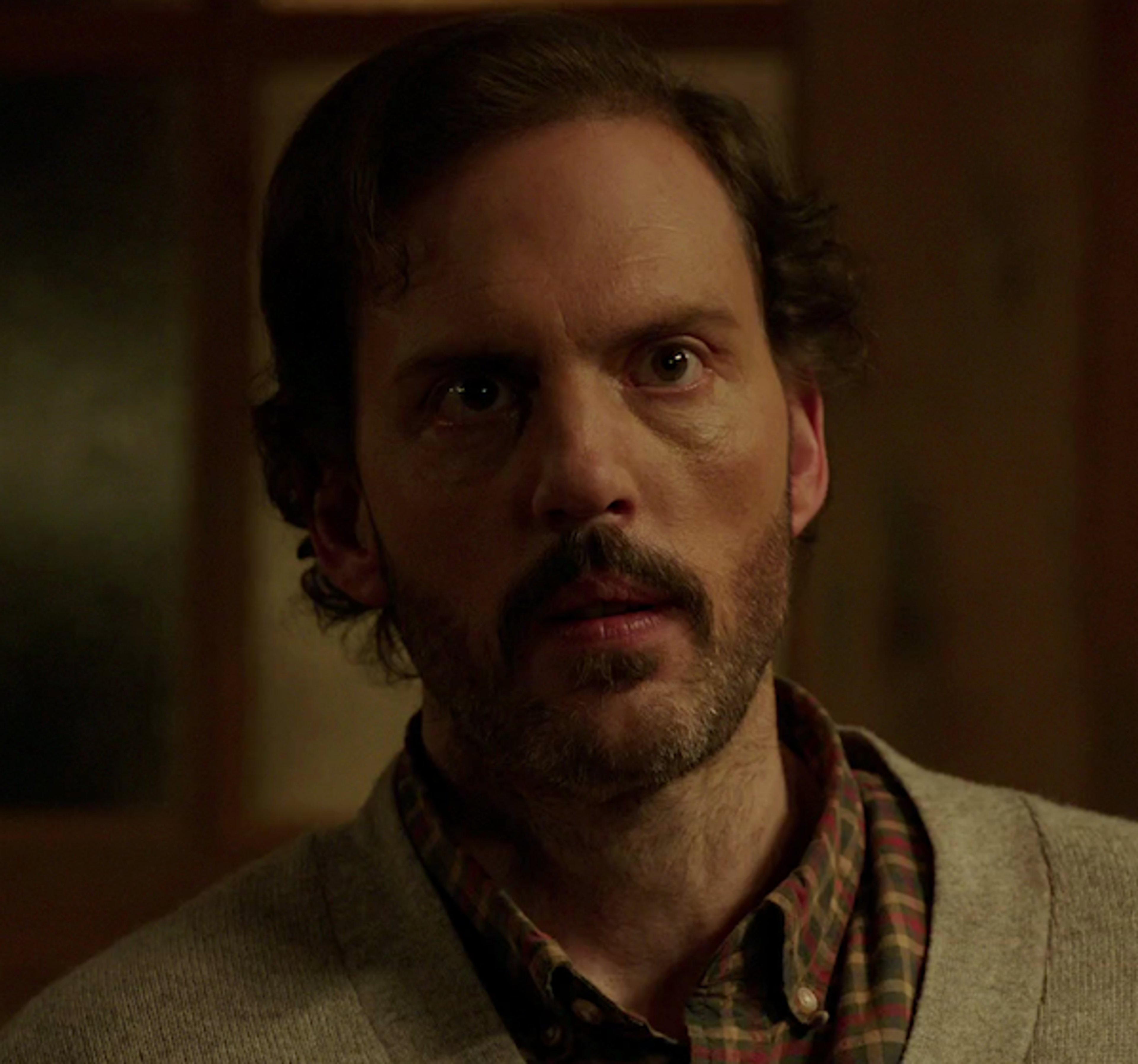 A man with a beard and long hair looking serious