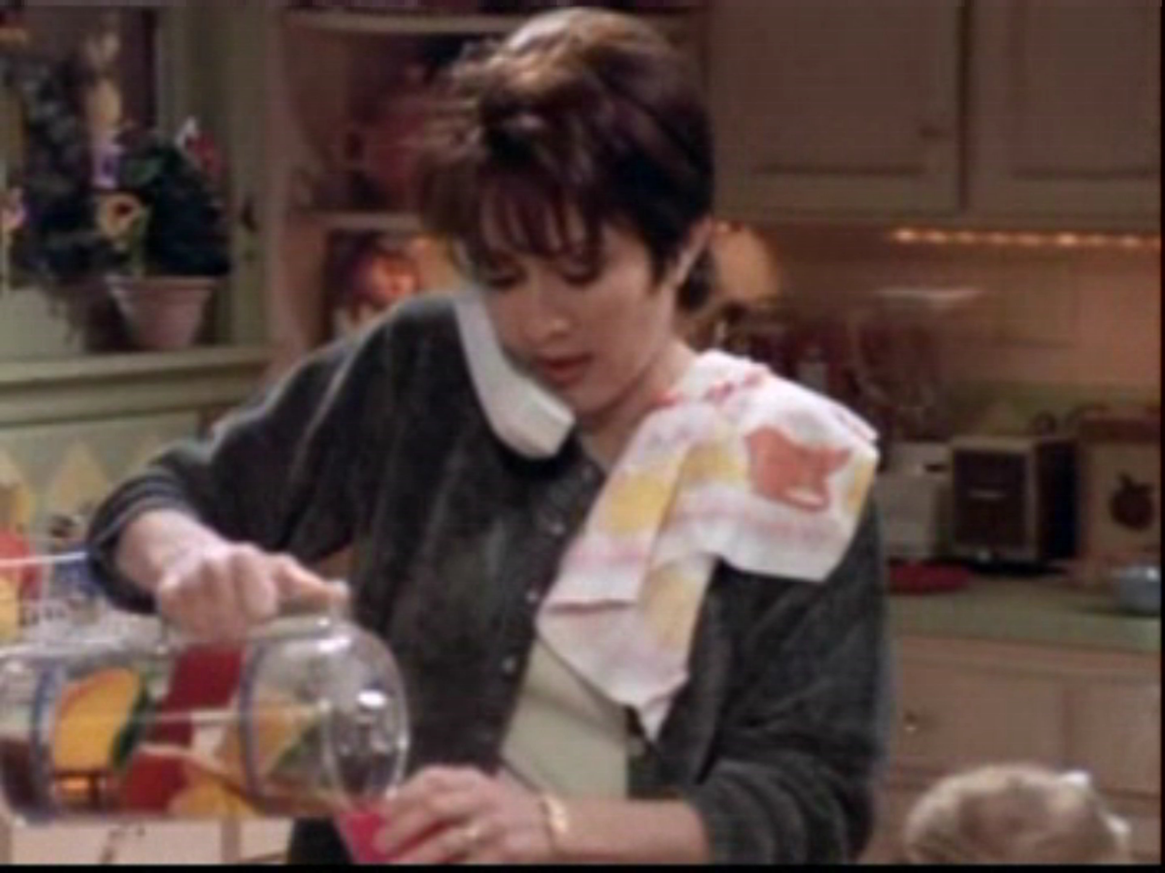 A middle-aged woman with short, dark hair in a kitchen setting