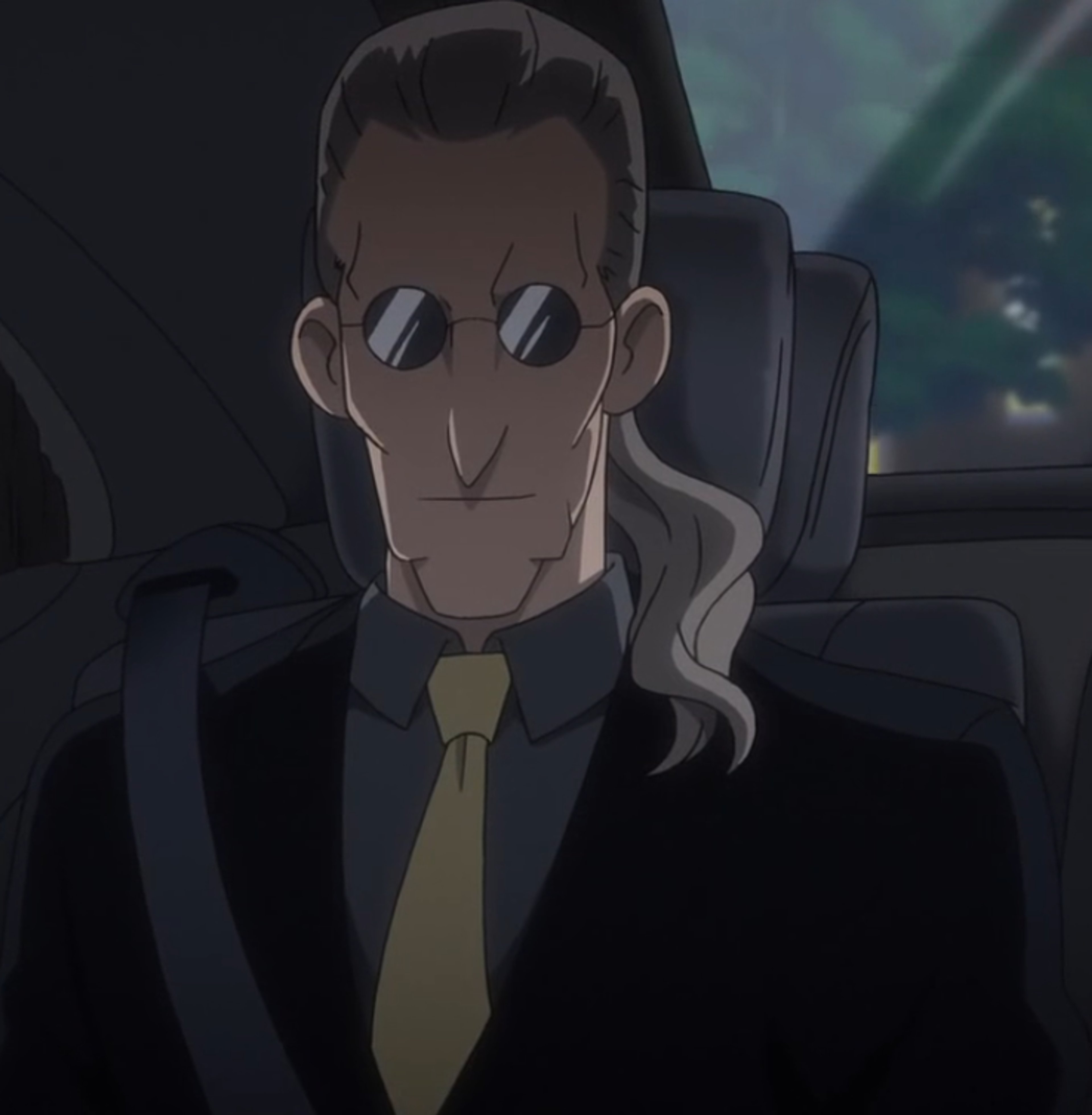A serious-looking older man in a suit and tie