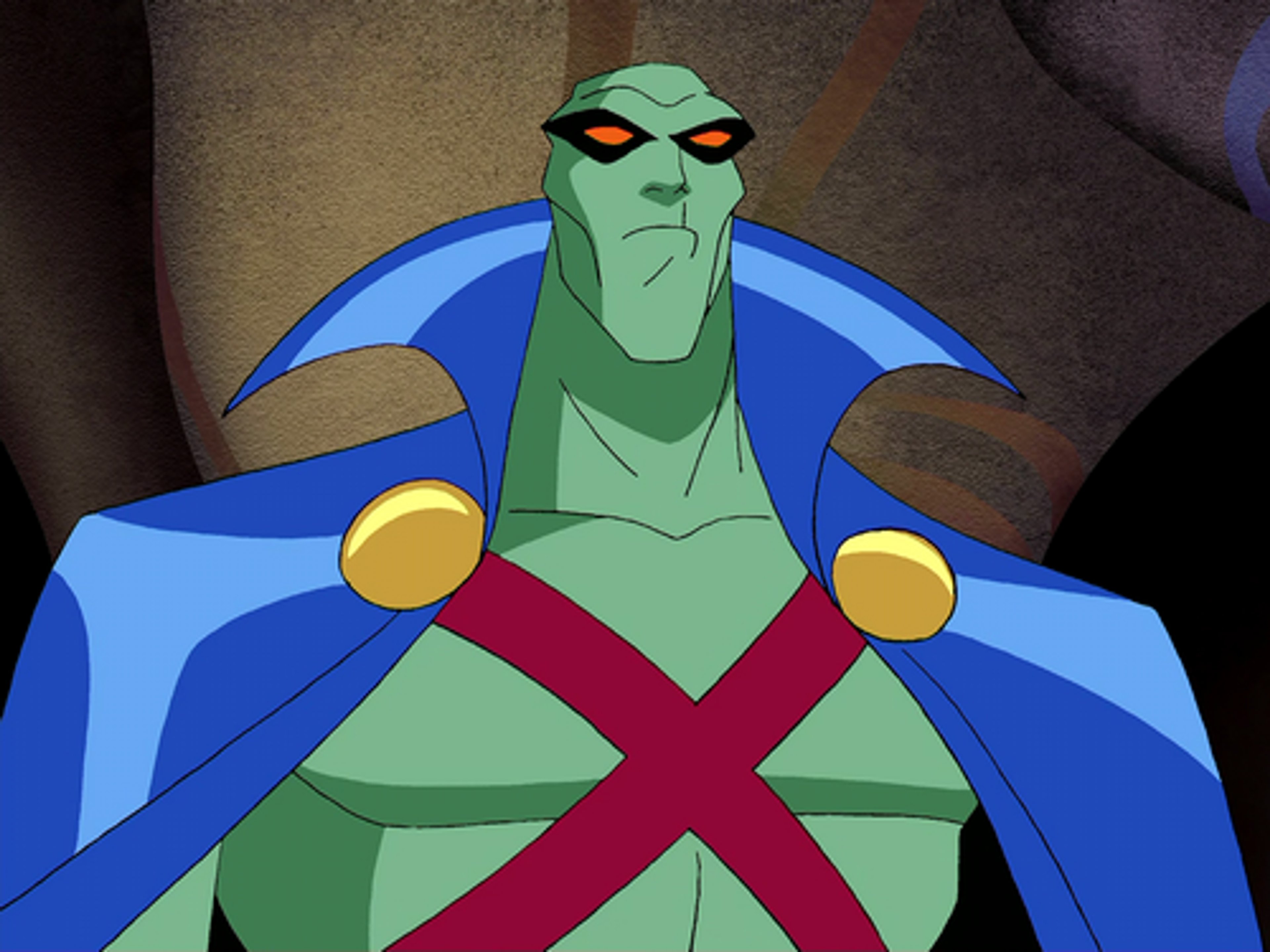 A green-skinned superhero character in a blue and red costume with an X symbol on the chest.