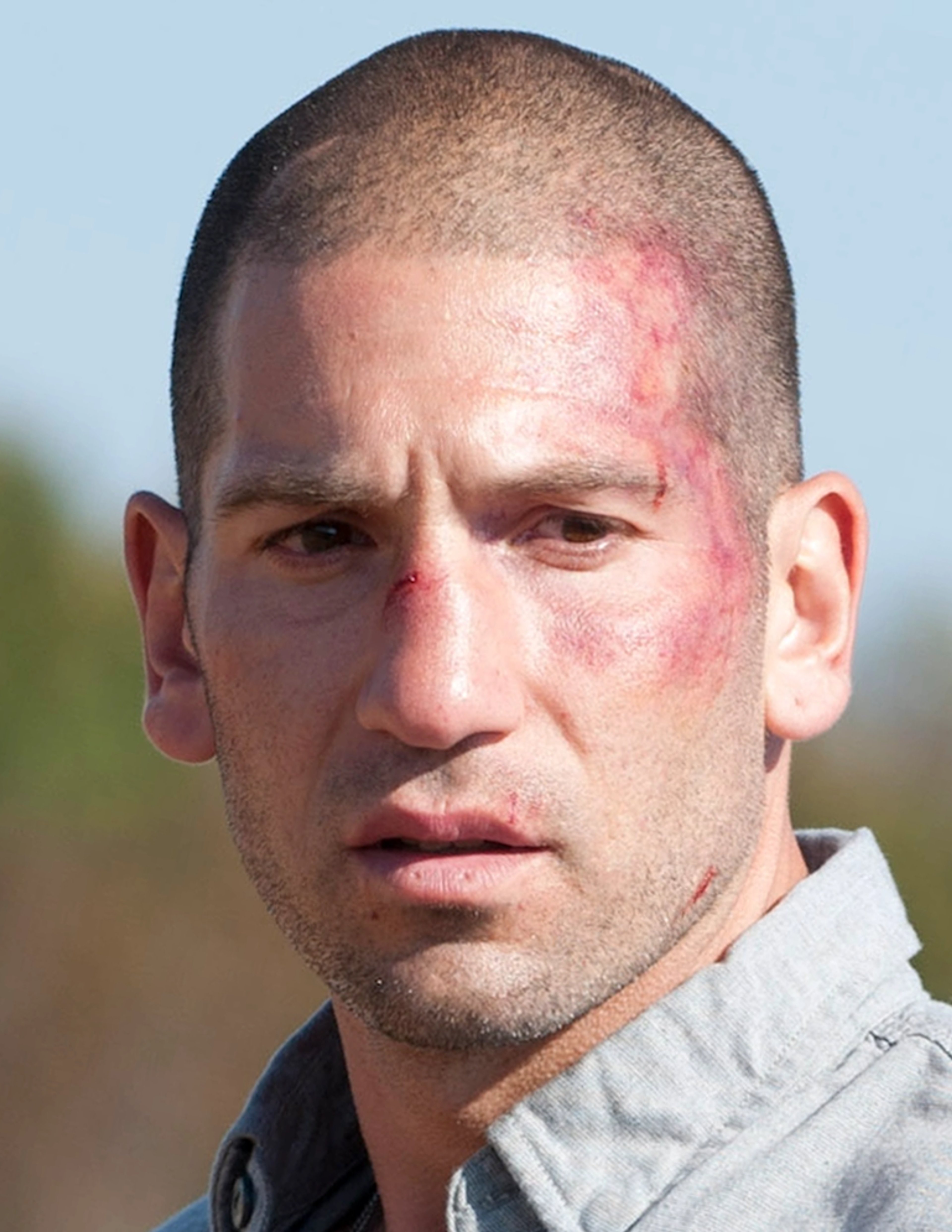 Close-up portrait of a serious-looking bald man with a rugged appearance