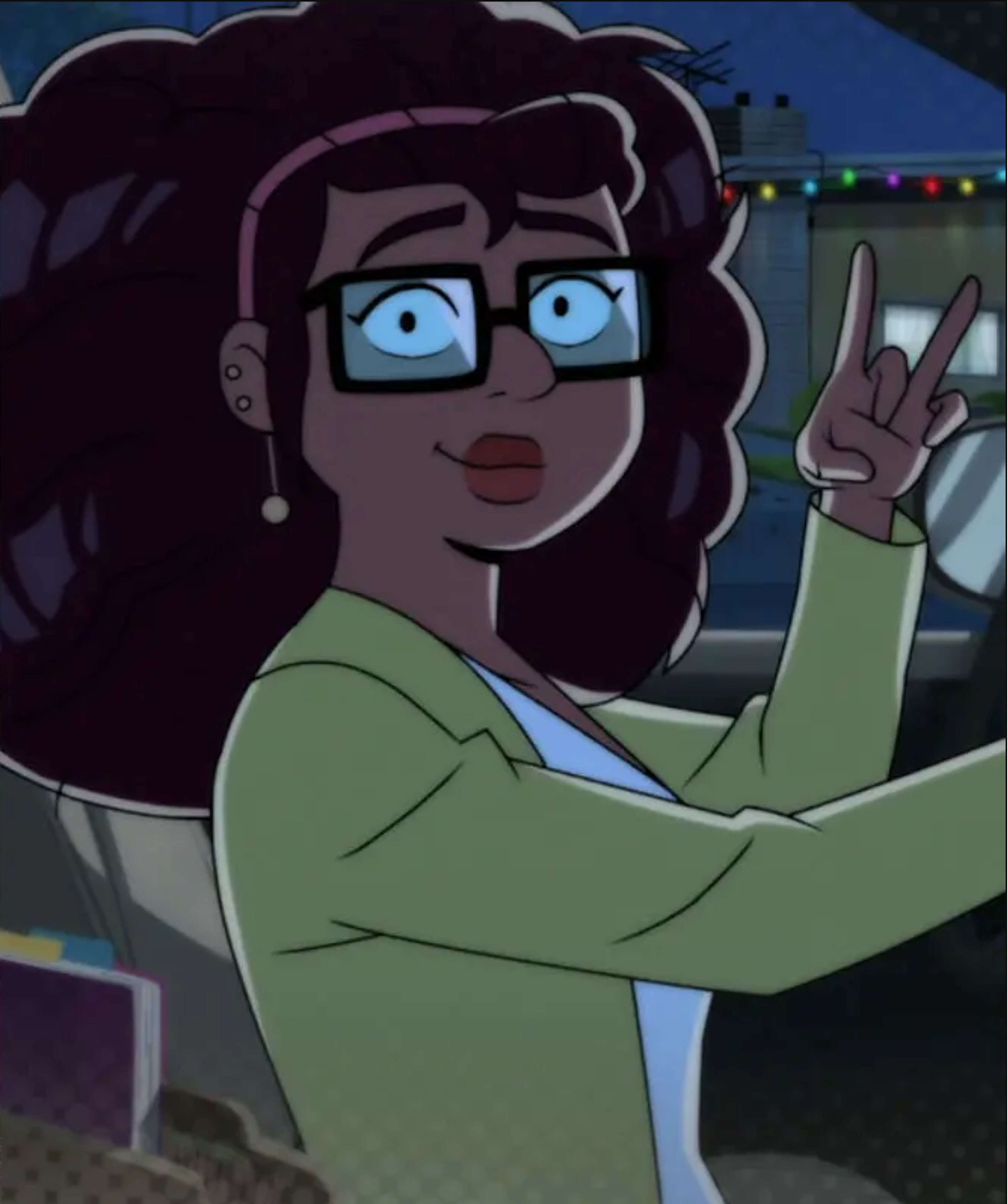 An animated female character with dark curly hair, glasses, and a green shirt making a peace sign gesture.