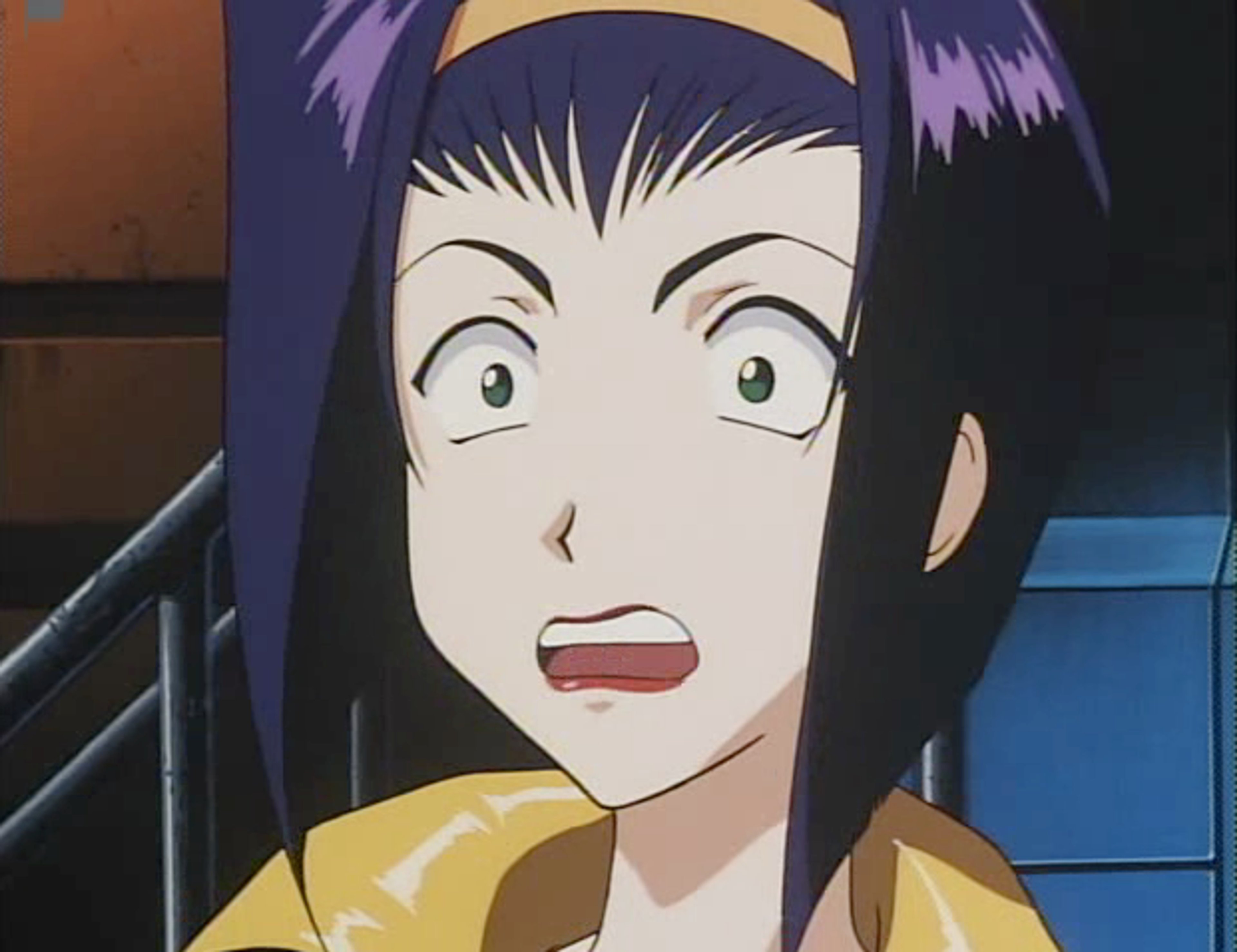 A young woman with purple hair and a surprised expression, wearing a yellow jacket.