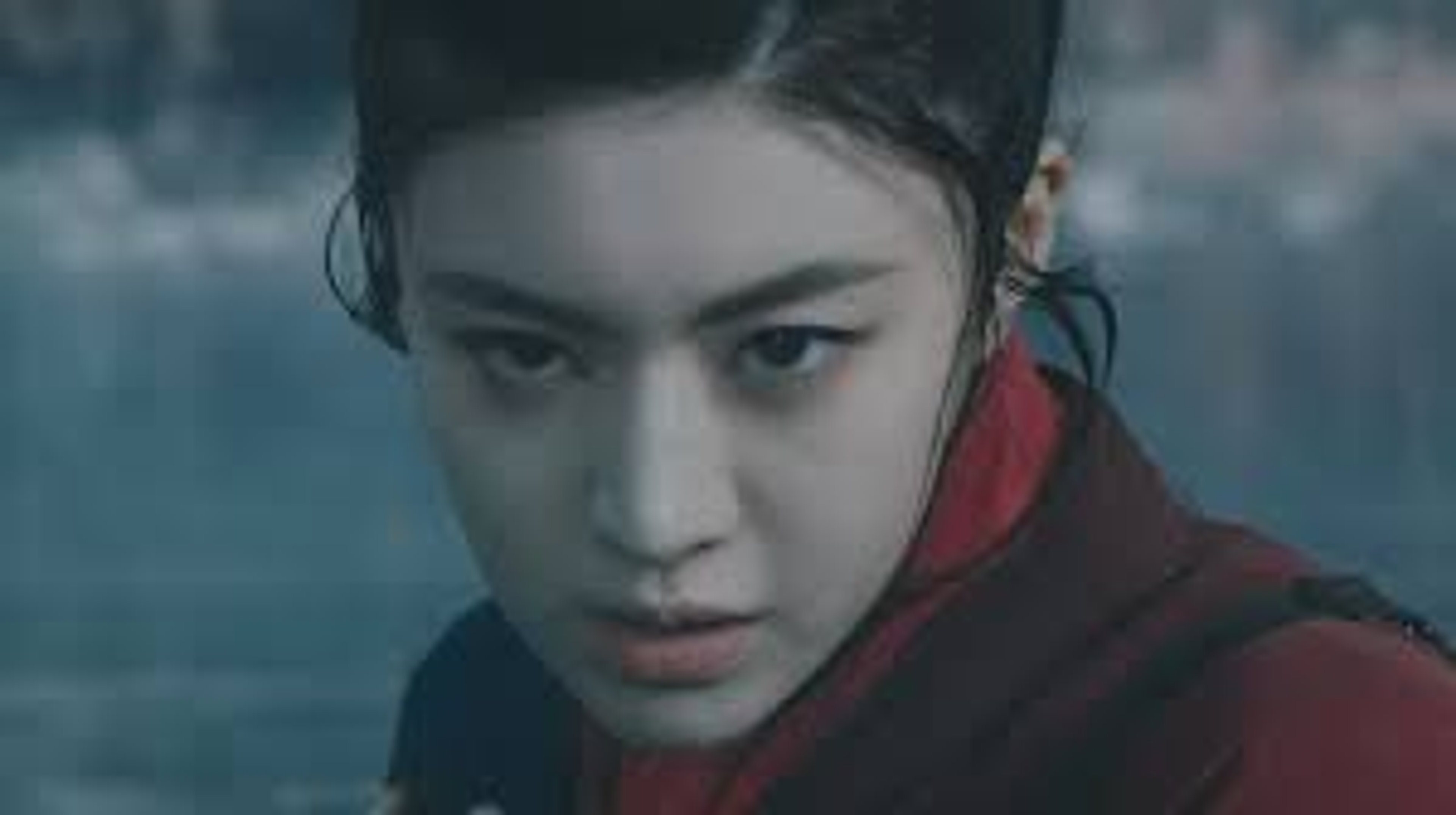 A young woman in a red robe or cloak in a martial arts stance