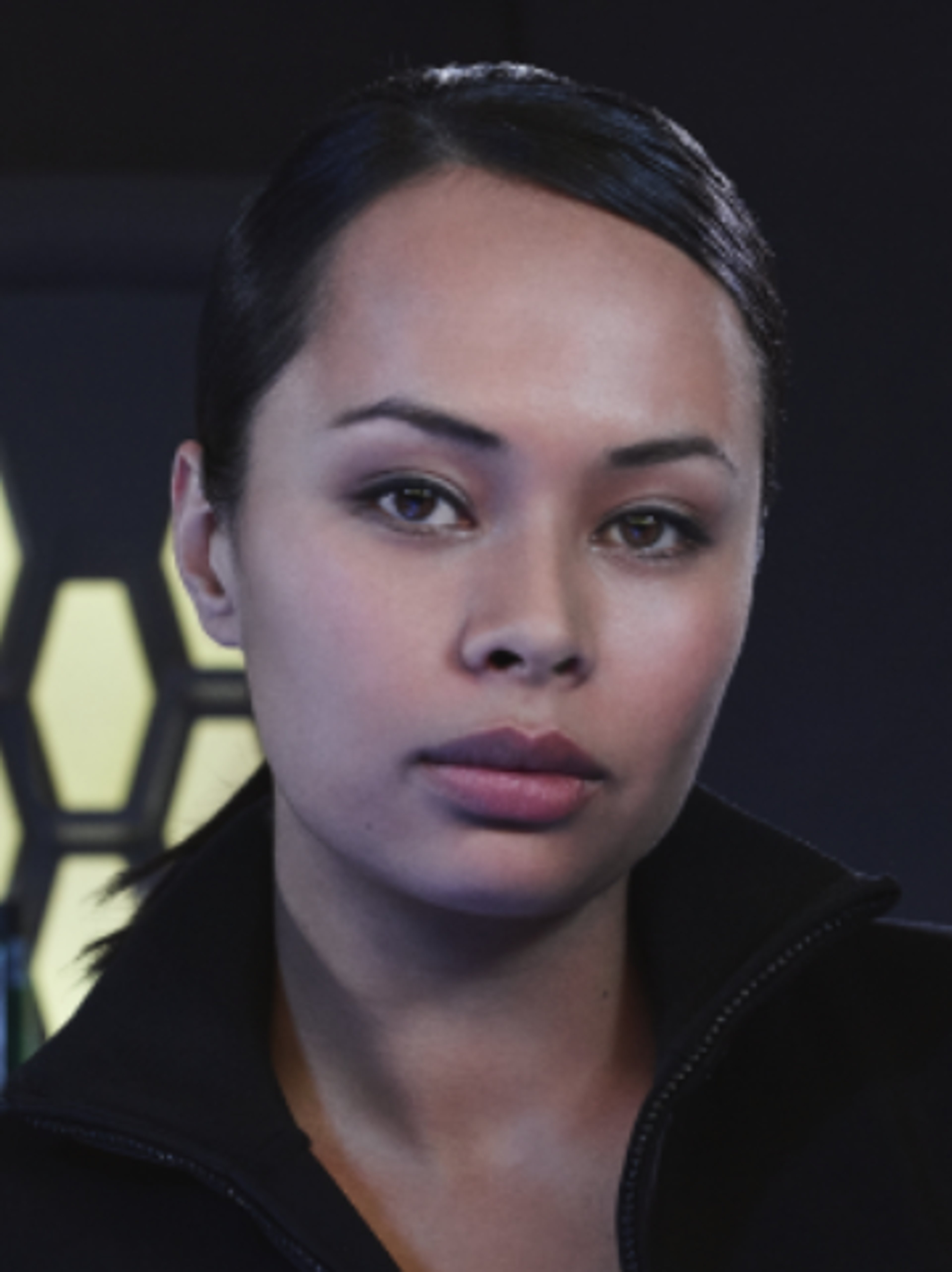 A close-up portrait of a serious-looking woman with dark hair