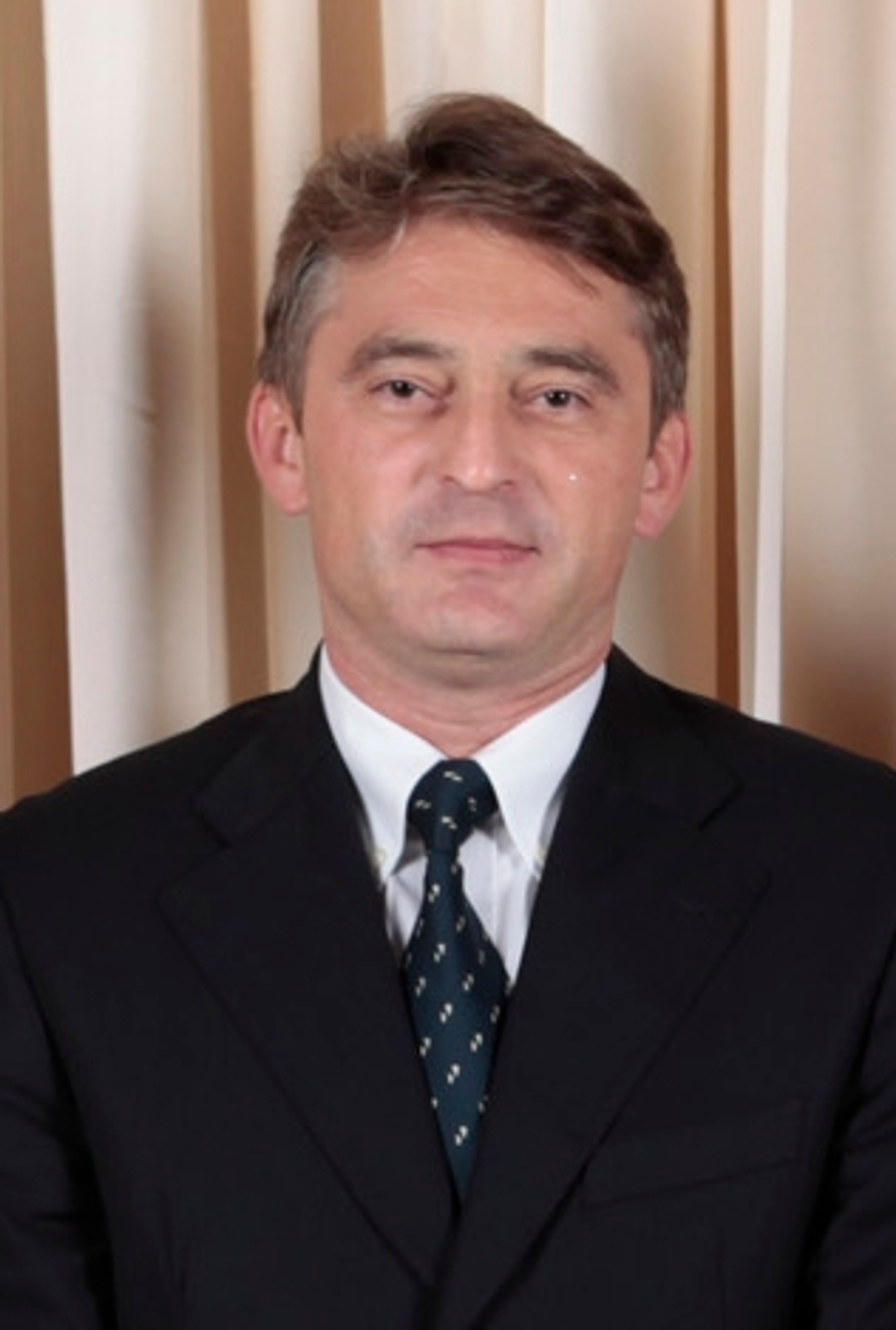 A middle-aged man in a suit and tie