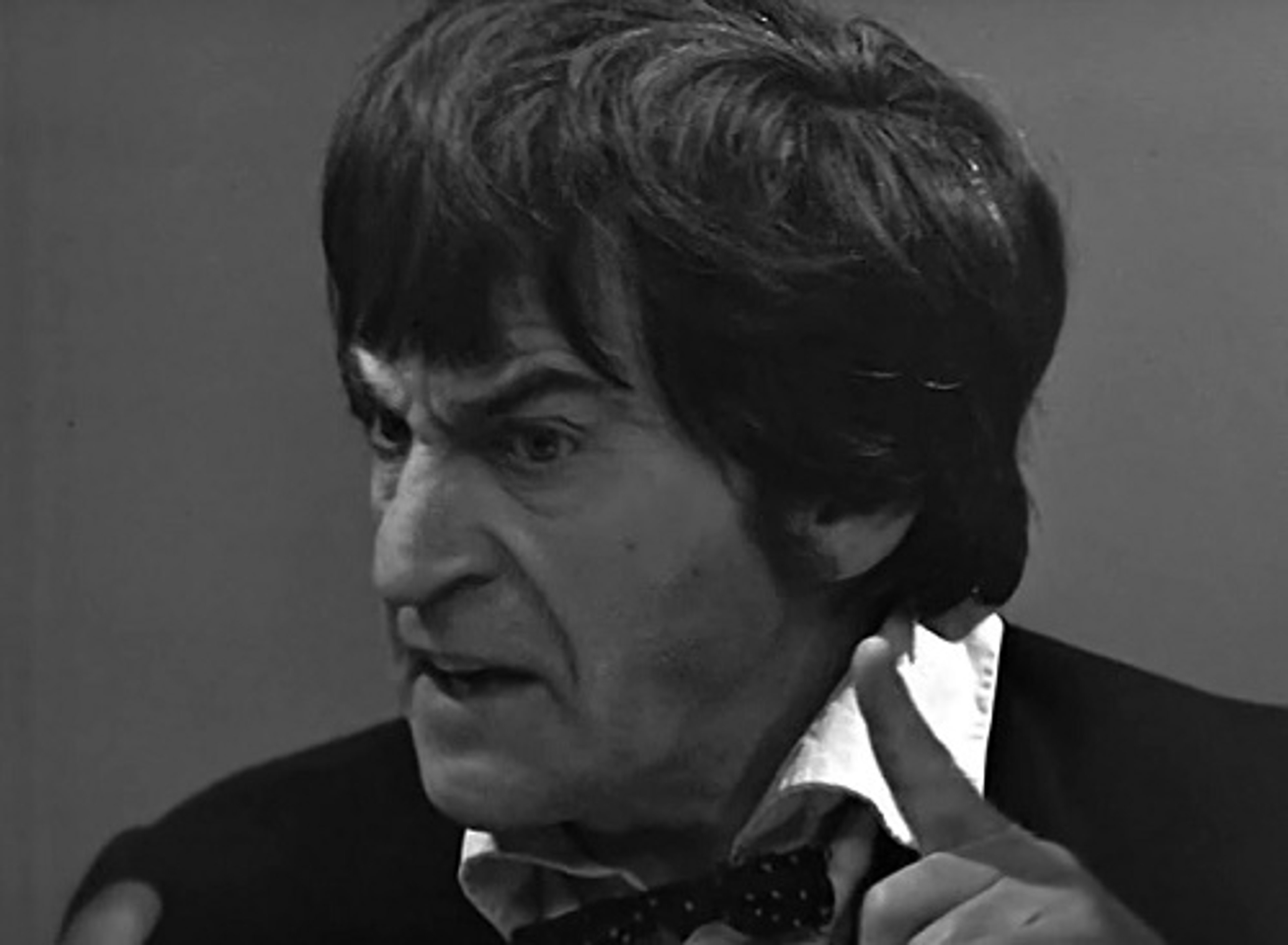 A man with disheveled black hair and a suit, appearing eccentric and intelligent